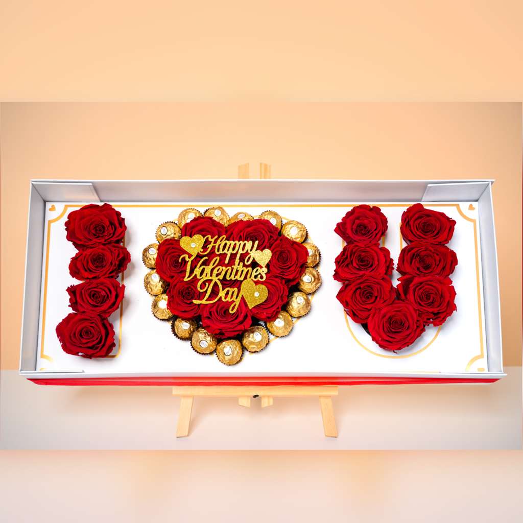 I LOVE YOU, Signature Box - A breathtaking luxury presentation spelling LOVE with premium red roses, centered by a heart-shaped arrangement surrounded by decadent Ferrero Rocher chocolates. Designed inside a refined keepsake box with gold accents, LOVE, Always is a grand declaration of romance and devotion.