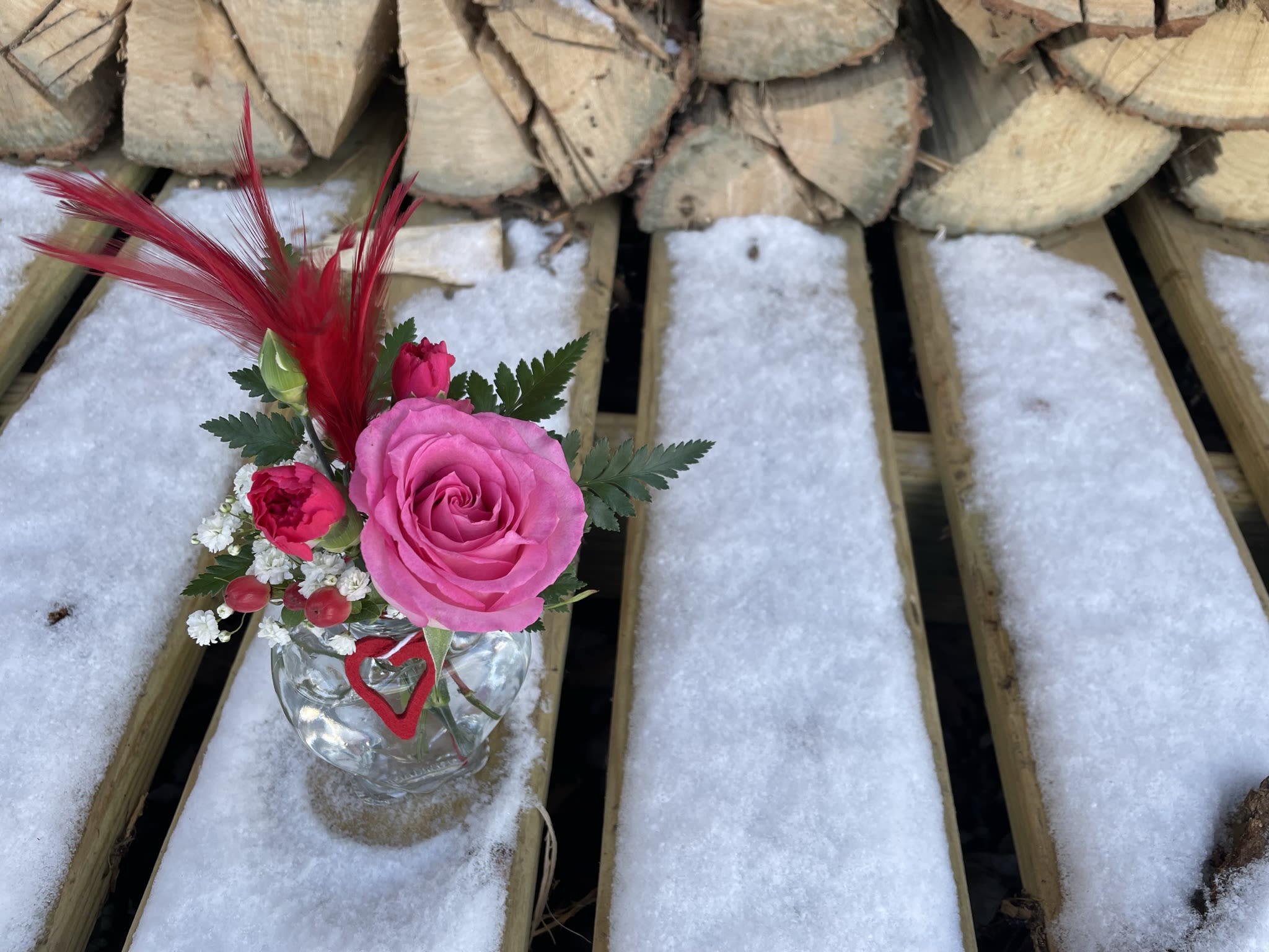 Kiss Arrangement - A heart shaped bud vase or mini mason jar with hearts filled with colorful pink and red flowers.  