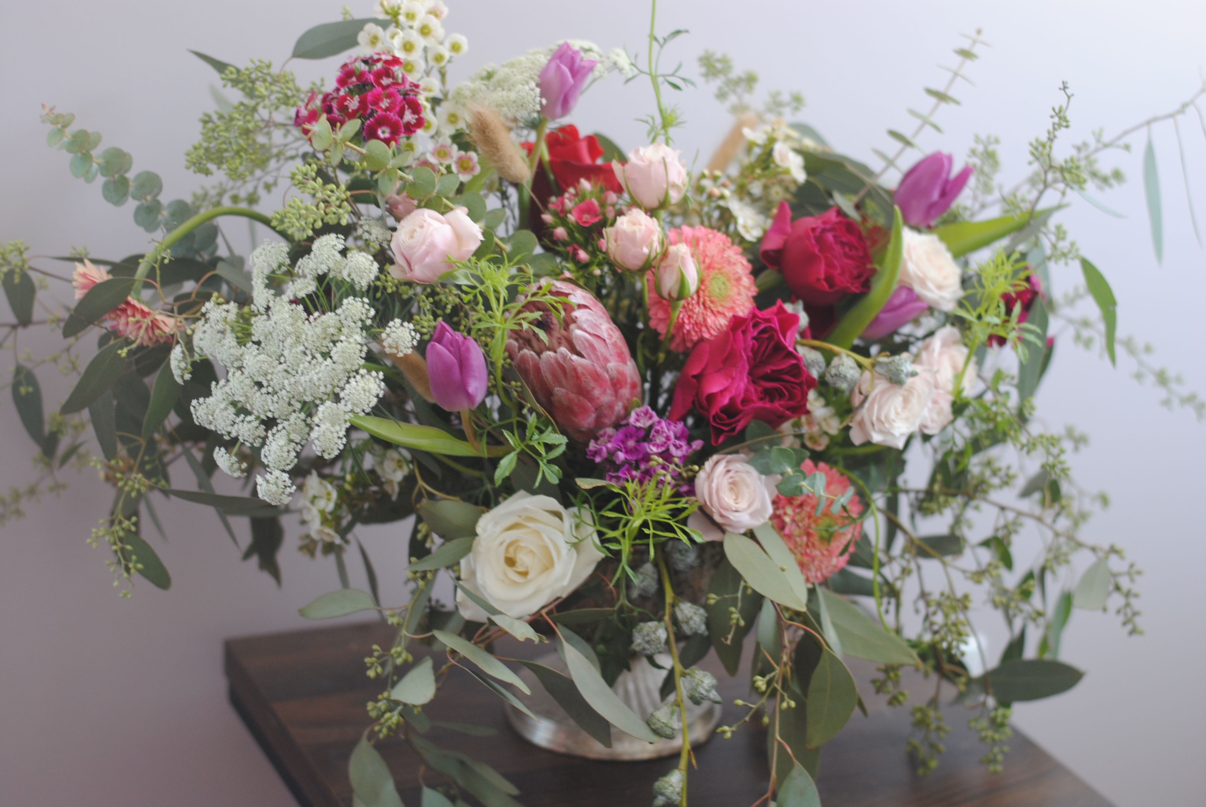 English Garden - Enjoy a cottage garden-scape in your home without any work!  American grown flowers burst out of a compote vase like they are part of a dance.  Each flower will continue to change, open, grow and dry over the course of its arrangement life.    Exact flowers used in these arrangements will vary.