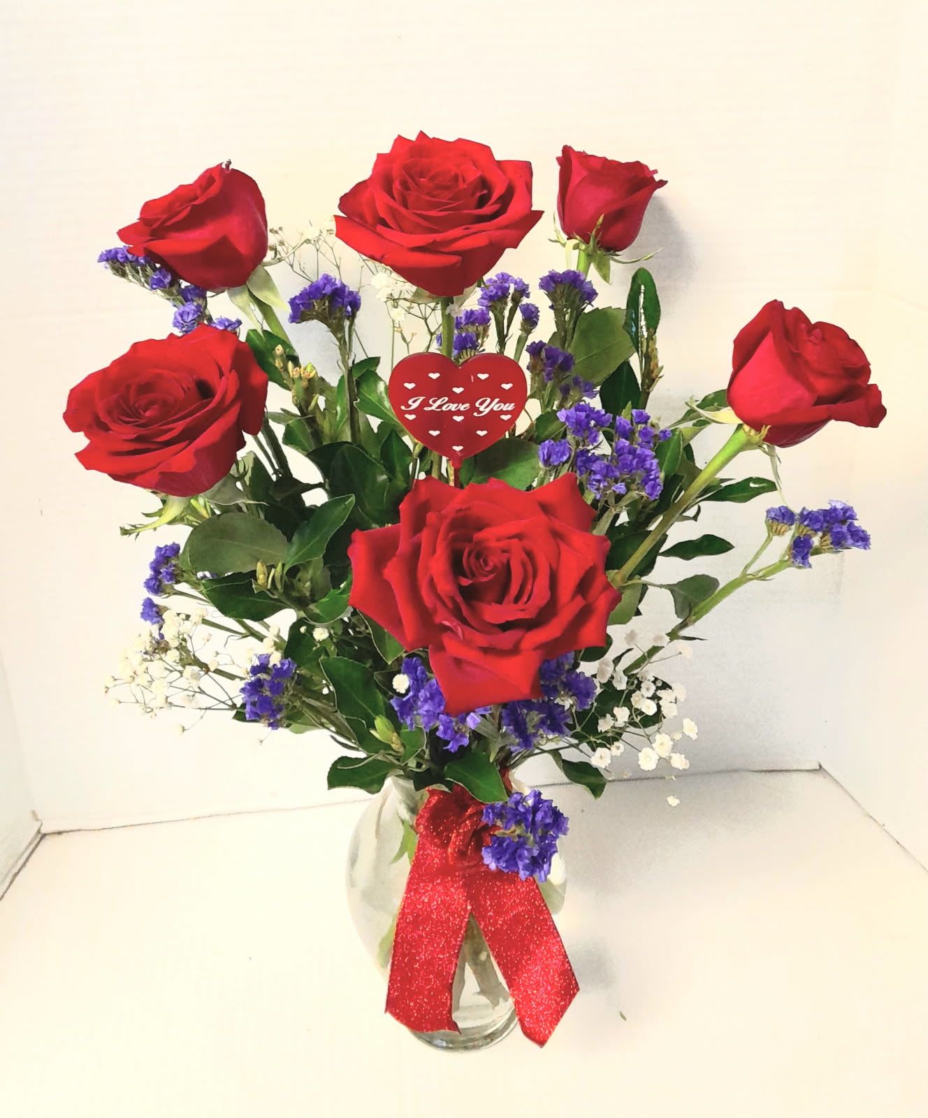 I love you red roses  - Six premium red roses in a clear vase with fillers greeneries and I love you