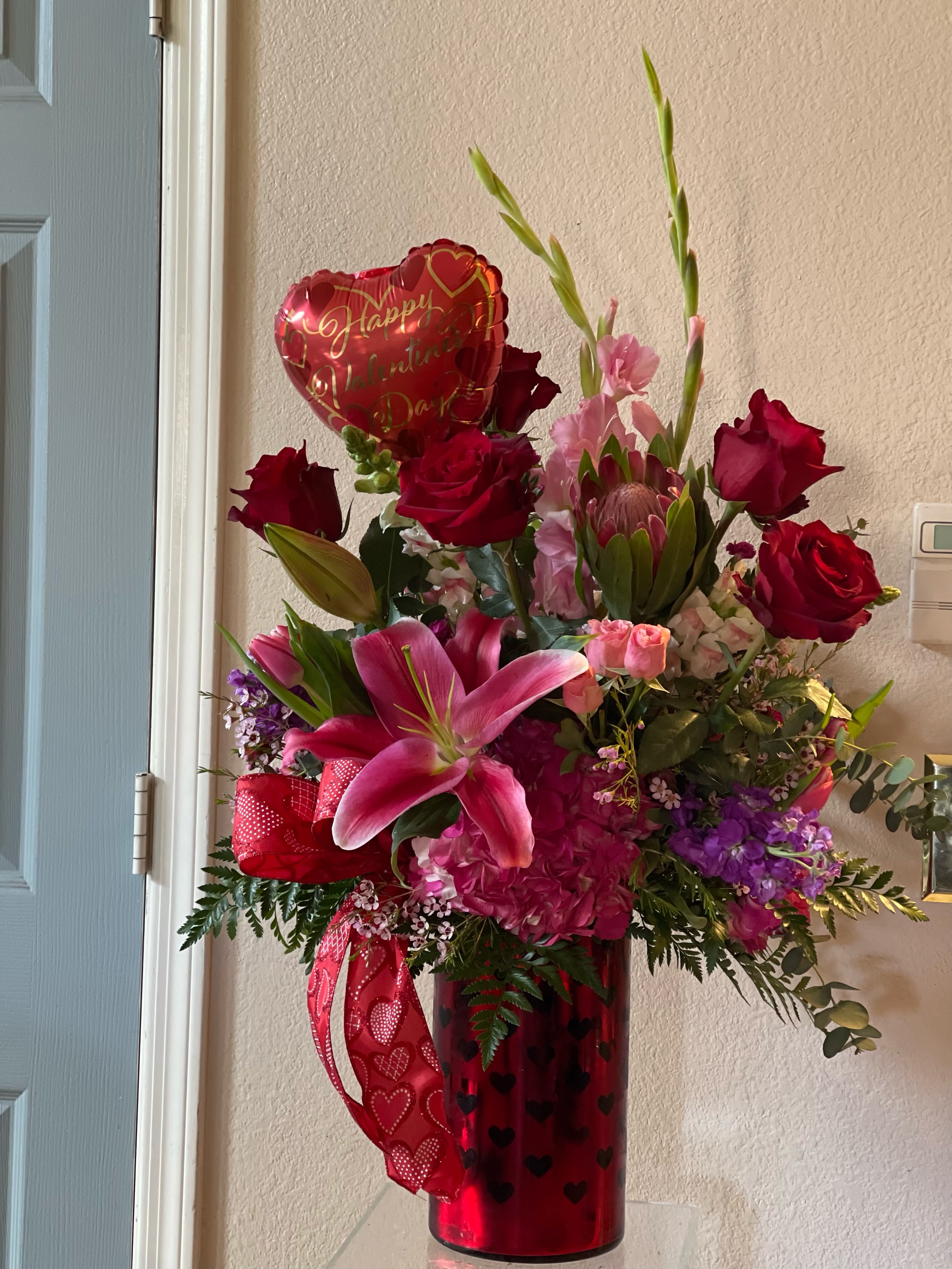 Valentines luxury  - Stunning assortment of high end florals in one our  exclusive valentines heart vases with a heart balloon.  When you want to send the best for Valentine’s Day ! 