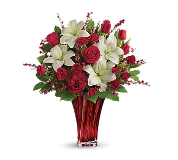 Love's Passion Bouquet - "Classic romance is this radiant bouquet of red roses, crimson tulips and pure white lilies, hand-delivered on Valentine's Day or any day in an exquisite blown glass vase. With its radiant red hue and unique twisting shape, it's sure to take their breath away! This passionate display of red roses, red spray roses, red tulips, and white asiatic lilies is accented with red leptospermum, leatherleaf fern, and lemon leaf. Delivered in a Love's Passion vase.   Orientation : All-Around  All prices in USD ($)  Standard  T17V200A  Deluxe  T17V200B  Premium  T17V200C"