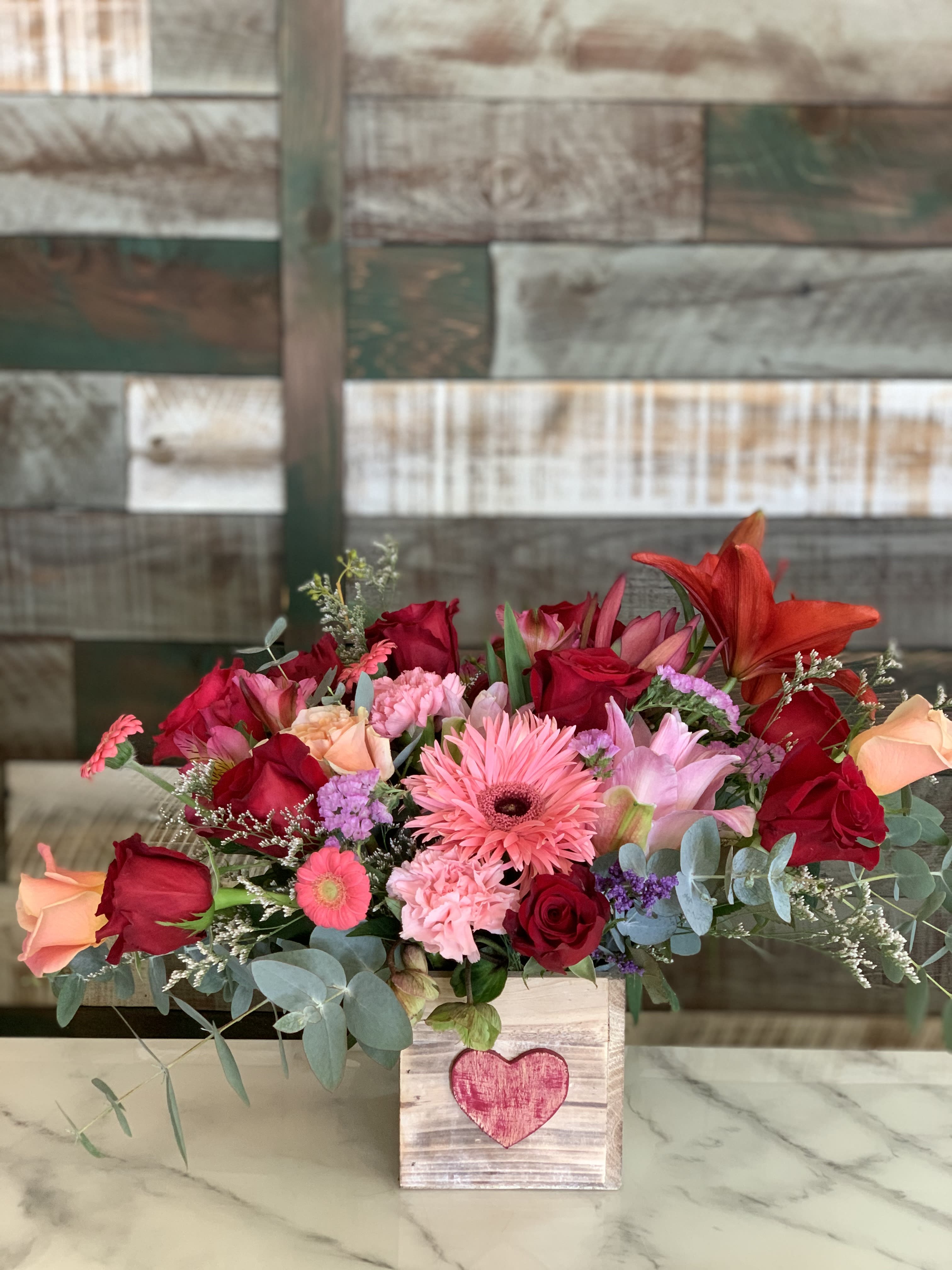 Rustic Chic - A dozen or so red and assorted roses with lilies, carnations, gerberas and assorted filler and greenery. So chic- sure to make someone so happy!!
