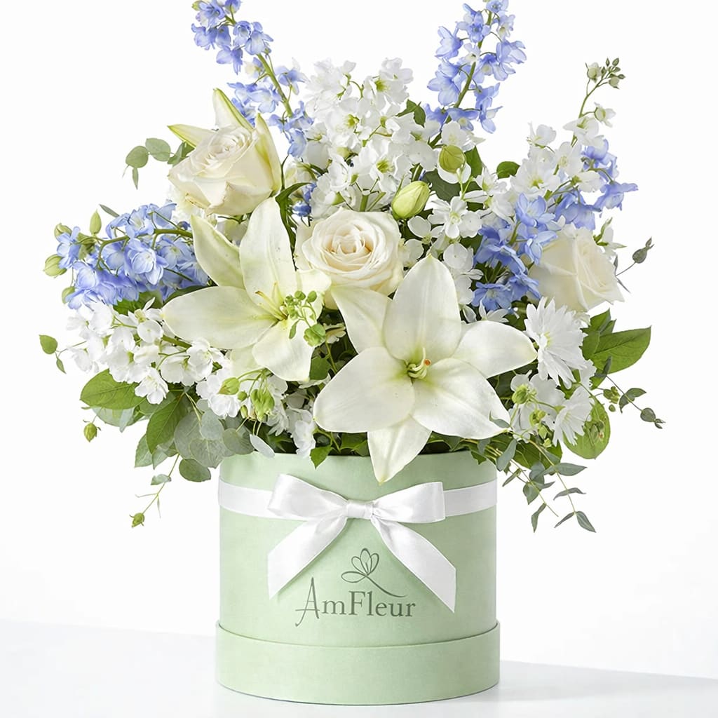 Flower Box ÂmFleur – Je t’aime délicatement  - A soft and elegant flower box featuring crisp white blooms, gentle blue accents, and fresh greenery. Light, refined, and full of subtle emotion, this arrangement expresses love with grace and delicacy. 