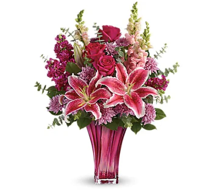 Bold Elegance Bouquet - When only the best will do for Mother's Day, surprise her with this incredible gift! Large and lush, this bouquet of hot pink roses, pink stargazer lilies and lavender mums is fragrant, feminine and fabulous. What an unforgettable treat when hand-delivered in this exquisite blown glass vase! This elegant bouquet features hot pink roses, pink stargazer lilies, burgundy stock, lavender cushion spray chrysanthemums, pink snapdragons, spiral eucalyptus, and lemon leaf. Delivered in a Bold Elegance vase.   Orientation : All-Around  All prices in USD ($)  Due to seasonal price increase on flowers, our prices will reflect an increase for this holiday on certain delivery dates.  Standard  TEV52-1A  Deluxe  TEV52-1B  Premium  TEV52-1C