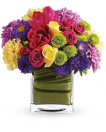 One Fine Day - Oh, what a fine day it will be when you have this delightful spring bouquet delivered to someone special. Everyone will delight in the vibrant colors and bountiful blossoms, all thoughtfully arranged in a beautiful leaf-lined vase. Light yellow roses, hot pink spray roses, tulips and gerberas, yellow carnations, green button spray chrysanthemums and lavender cushion spray chrysanthemums are delivered in an exclusive cube vase. You'll have many fine days when you send this beautiful bouquet! 