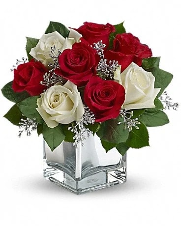 Snowy Night Bouquet - Go contemporary this Christmas with a trendy mirrored cube filled with lush red and white roses. This exciting bouquet offers an affordable way to make a huge impression on your host or hostess. They'll love the gift - you'll love the welcome. The delightful holiday bouquet features red roses and white roses accented with assorted greenery.