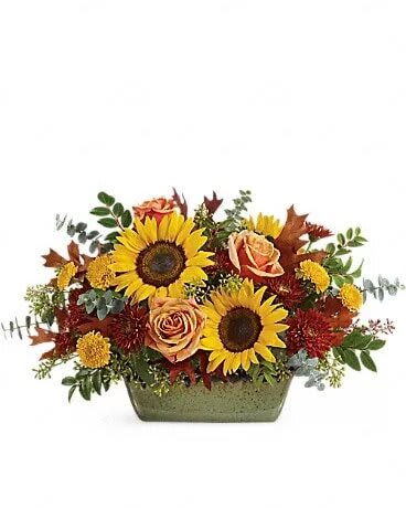Sunflower Farm Centerpiece - Bursting with fall cheer, this radiant autumnal arrangement arrives in a hand-glazed, oven-to-table stoneware dish for years of baking and serving delight! This stunning centerpiece includes yellow sunflowers, peach roses, yellow button spray chrysanthemums, burgundy cushion spray chrysanthemums, spiral eucalyptus, huckleberry, seeded eucalyptus and transparent brown oak leaves. Delivered in a Country Oven dish.