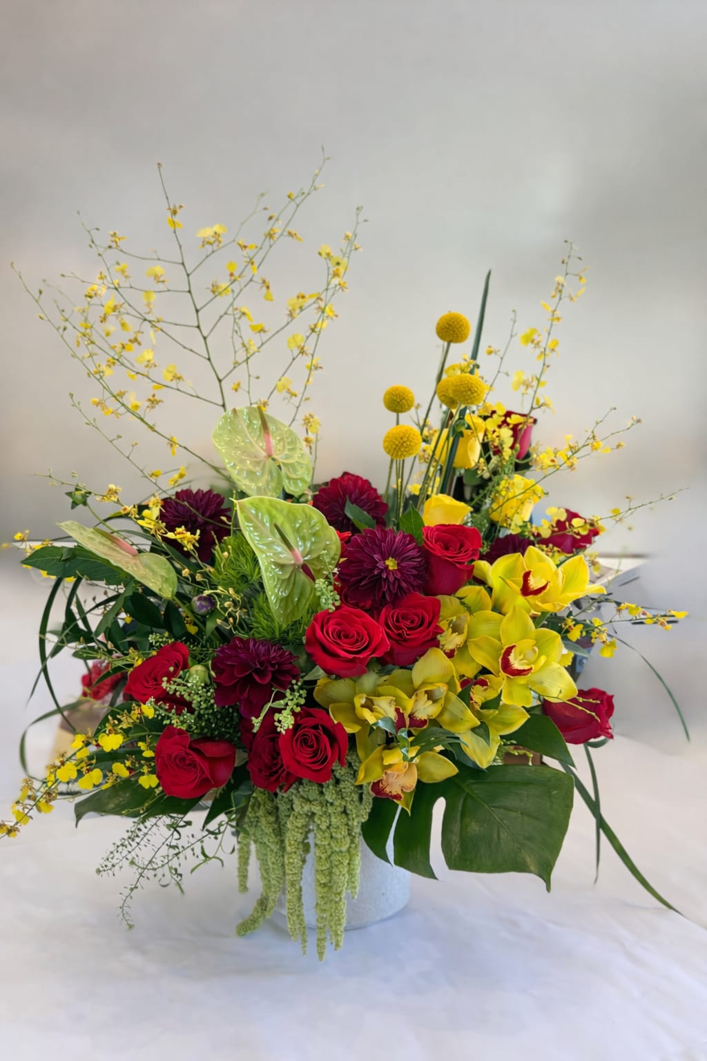 Happy Spring Blooms - Flowers: roses, anthurium, cymbidium orchids, dahlias, forsythia, billy balls, amaranthus, monstera leaves, and greenery. 