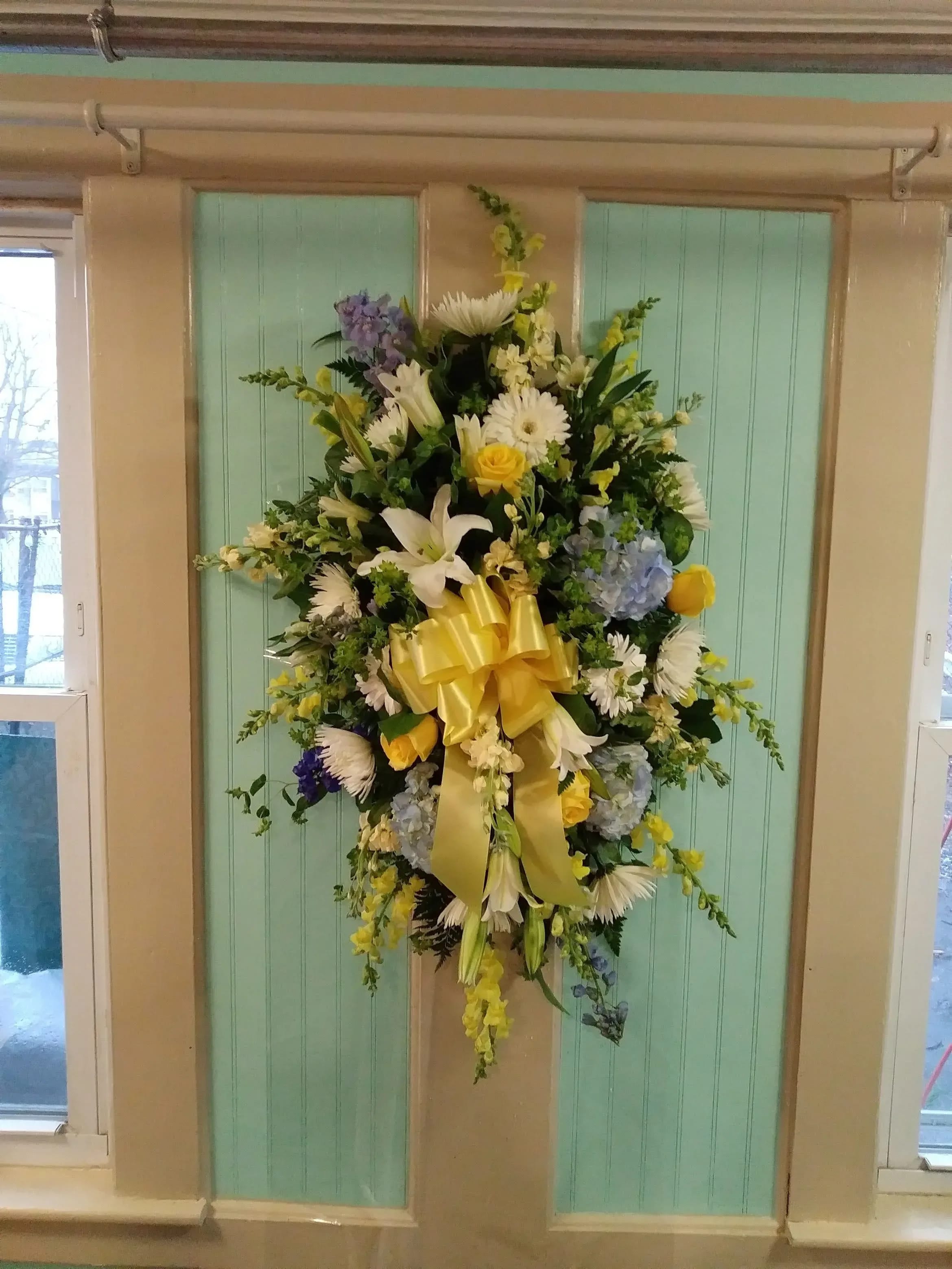 Funeral Spray - Beautiful yellow, blue and white floral mix to pay tribute to your loved one.