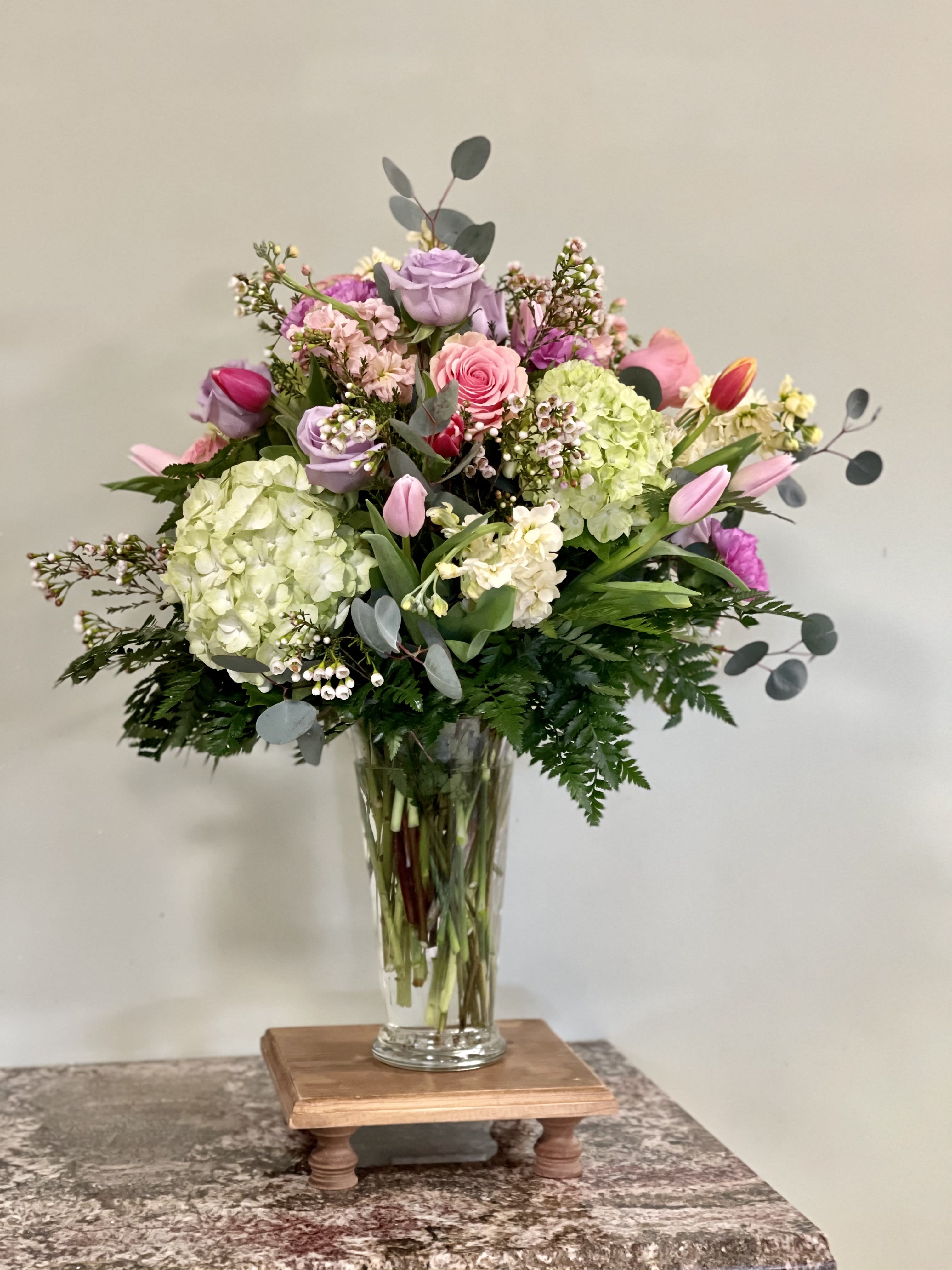 The Legacy Spring Garden Arrangement - This gorgeous arrangement of tulips, roses and lush green hydrangeas in beautiful colors is sure to please all flower lovers.