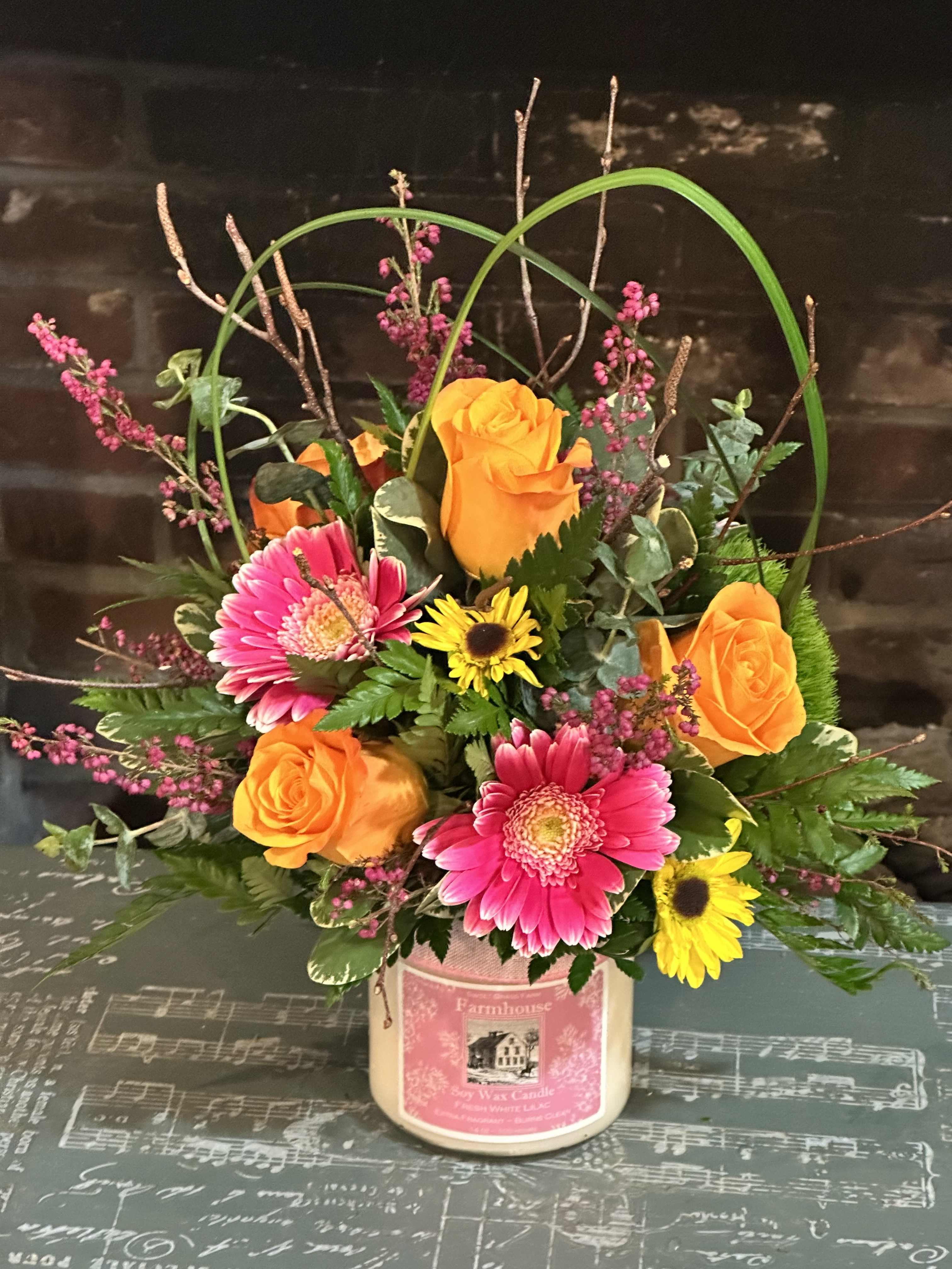 Sweet Grass Farm Keepsake Candle - An arrangement of fresh flowers atop a Sweet Grass Farm Fragrant Candle. This is a great Keepsake gift that keeps on giving!