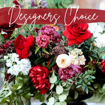 Designer's Choice Ruby Reds - Designer’s Choice – Ruby Reds Bold, romantic, and timeless, our Designer’s Choice: Ruby Reds arrangement is a striking florist-designed creation featuring rich red blooms accented with fresh, seasonal greenery. This classic color palette evokes passion, elegance, and heartfelt emotion, making it a perfect choice for meaningful moments. Each arrangement is uniquely crafted by our designers using the freshest flowers available, allowing for natural variation while maintaining a lush, red-forward look. Ideal for anniversaries, love and romance, celebrations, sympathy, or whenever you want to make a powerful statement. Flowers and containers may vary based on availability, but every design is thoughtfully composed to feel full, balanced, and beautifully expressive. Details: Custom designer arrangement in a rich ruby-red color palette Seasonal blooms selected at peak freshness Designed in a coordinating vase or container Each arrangement is handcrafted and one-of-a-kind Trust our designers to create a stunning red arrangement that delivers classic beauty with lasting impact.