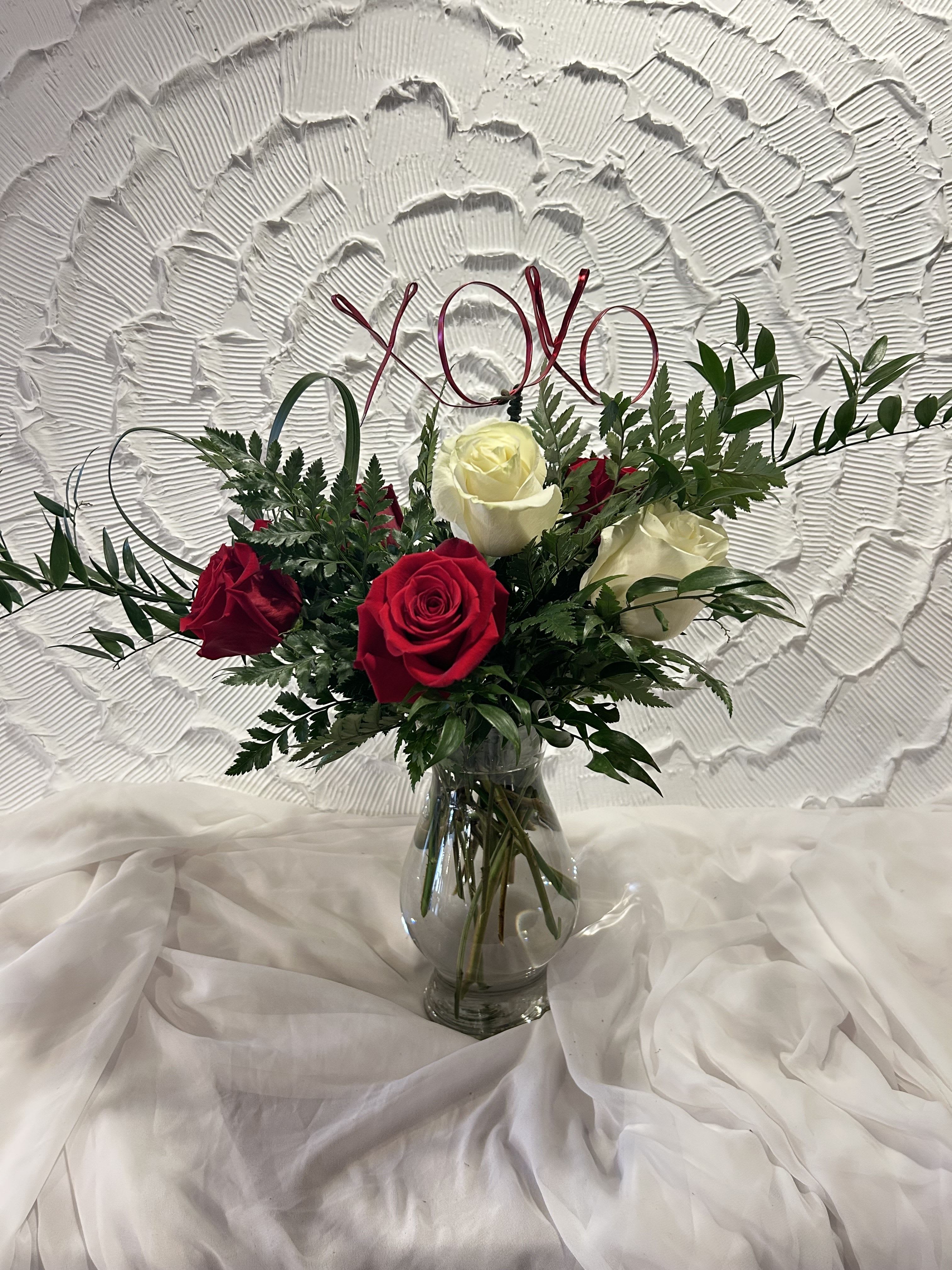 XOXO - With hugs and kisses, this vase is also made with red and white roses, Italian ruscus and a custom XOXO design. Have this arrangement make your Valentine's Day special 