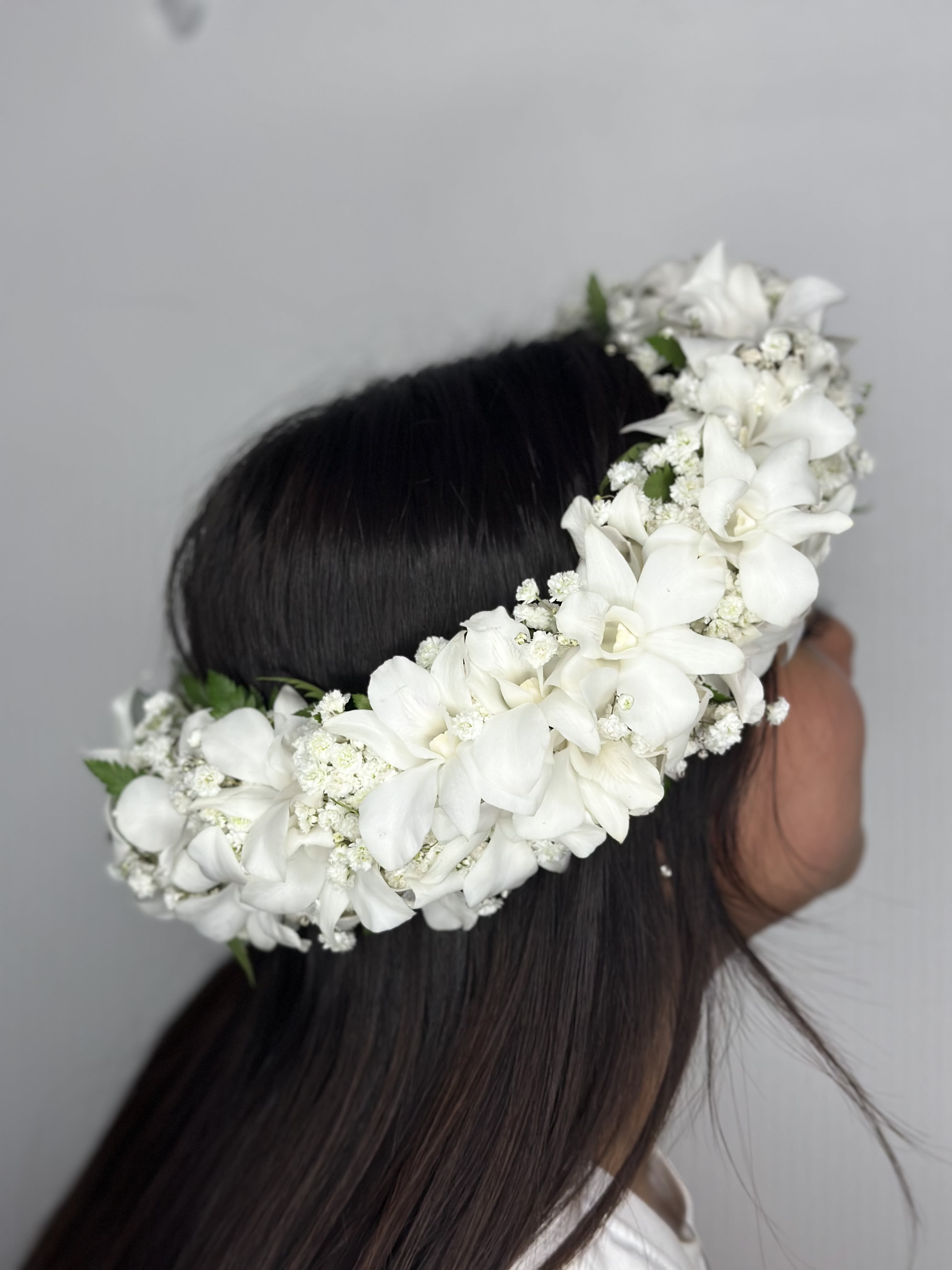 White Angell Lei Po'o - A white lei po'o (Hawaiian flower crown) made with orchids and baby's breath is an elegant and timeless floral accessory, often used for weddings, graduations, hula performances, or other special celebrations.