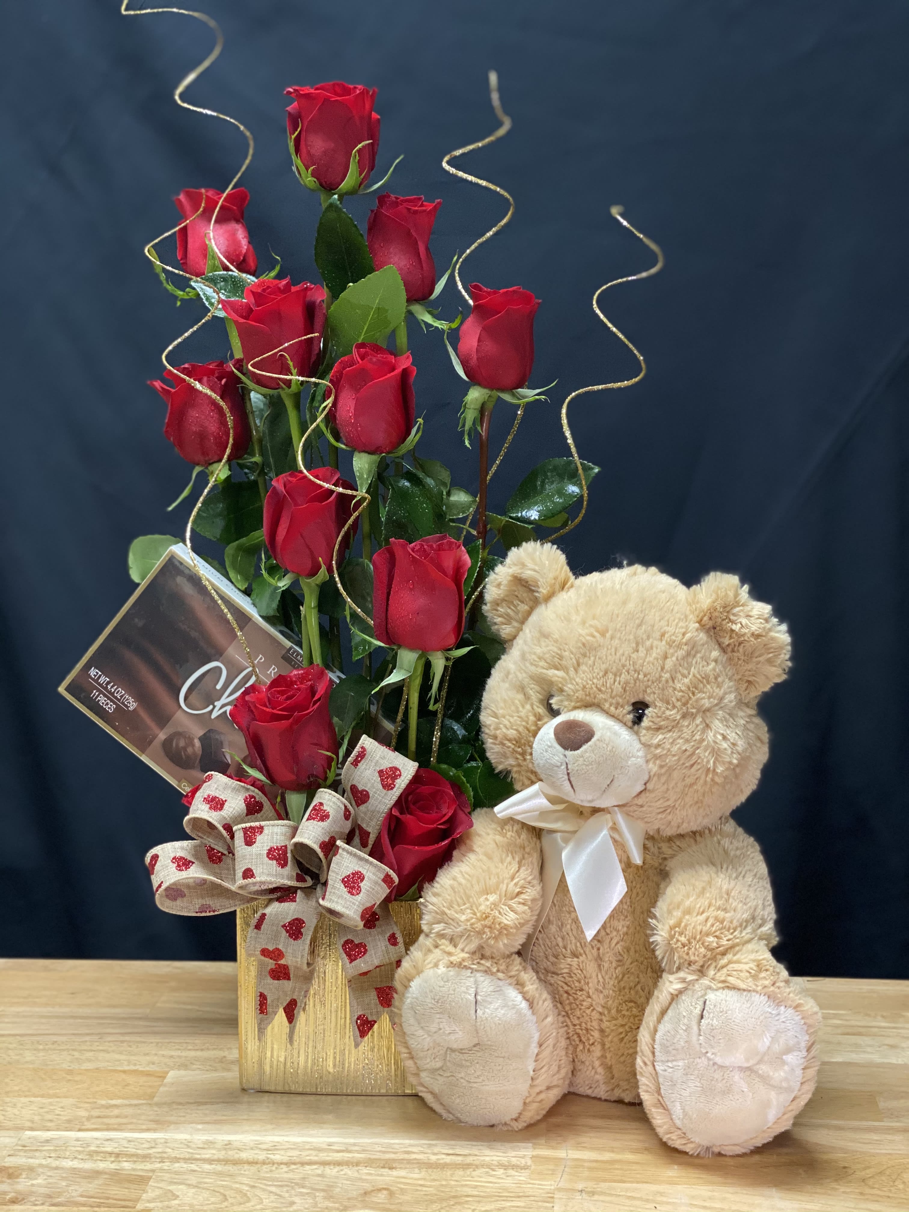 Cuddle Bundle  - Red Roses, chocolates and a cuddley bear , one-sided arrangement includes a dozen red roses, a cute cuddle bear and a box of chocolate   Deluxe $216.00 18 roses Premium $265.00 2 dozen roses                                                   Gund bear
