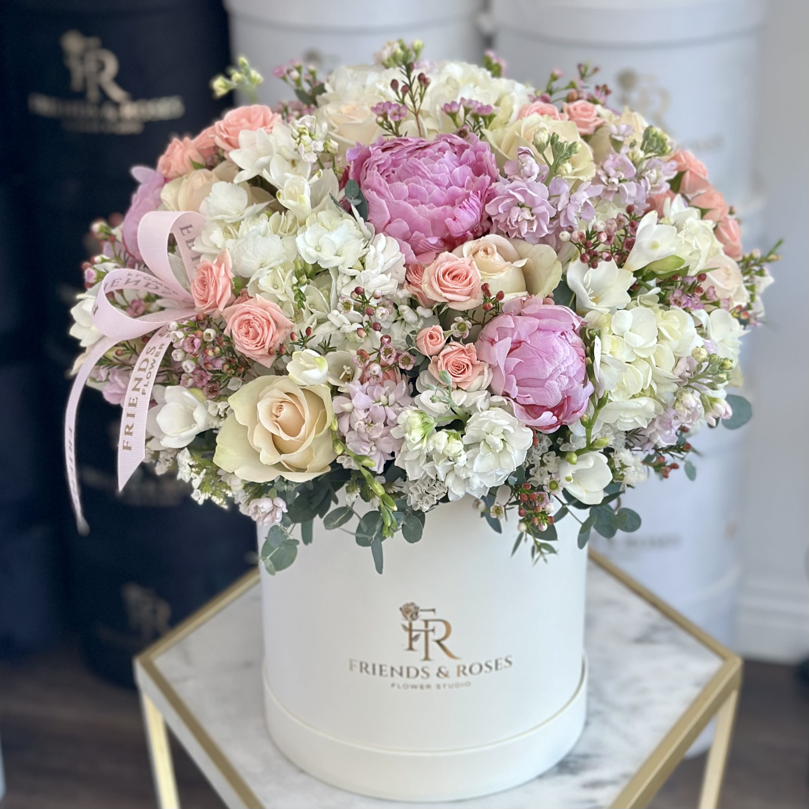 Gabby - Elegant pastel flower arrangement featuring soft pink peonies, blush and ivory roses, and delicate seasonal blooms, beautifully styled in a luxury white box. A timeless floral design perfect for celebrations, gifts, or refined home decor.