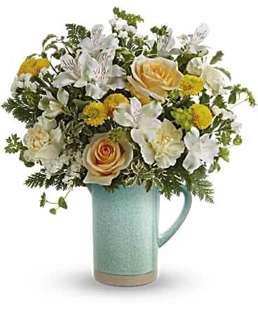 Teleflora's Adored Aqua Bouquet - Everyone adores this stunning springtime surprise, with its fresh white and yellow blooms and pretty-meets-practical stoneware pitcher that's both a vase and a food-safe serving piece! This bouquet features yellow roses, white alstroemeria, peach carnations, yellow button spray chrysanthemums, white sinuata statice, bupleurum, pitta negra and leatherleaf fern. Teleflora's Adored Aqua Bouquet is delivered in Teleflora's Garden Beauty Pitcher. Orientation: All-Around