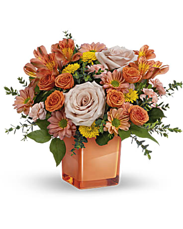 Teleflora's Orange Splendor Bouquet - Orange splendor! Celebrate any season, with this lush orange bouquet, artfully gathered in a fabulous coral glass cube vase. This bouquet features light orange roses, coral spray roses, peach alstroemeria, peach miniature carnations, yellow button spray chrysanthemums, and bronze daisy spray chrysanthemums. Delivered in a Coral Color Splash Cube. Orientation: All-Around  SUBSTITUTION POLICY – Always deliver the freshest flowers! Please note the bouquet pictured reflects our original design.  If the exact flowers or container in this arrangement are not available, our local florists will create a beautiful bouquet with the freshest available flowers.