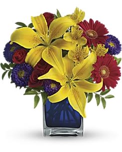 Teleflora's Blue Caribbean - Martinique, St. Maarten, any tropical paradise is the perfect setting for this explosively colorful bouquet in a chic blue contemporary cube vase. Can't go just now? Bring the island home. The exciting bouquet includes yellow Asiatic lilies, red miniature gerberas, purple Matsumoto asters, red spray roses and yellow alstroemeria accented with fresh greenery. Delivered in a blue contemporary glass cube vase. Orientation: All-Around