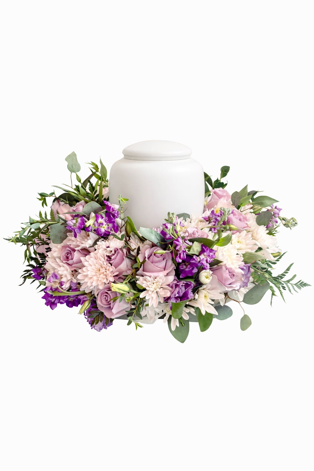 Eternal Grace – ÂmFleur Tribute - Eternal Grace is a refined floral tribute created to honor a life with serenity, beauty, and heartfelt intention.  This graceful arrangement surrounds the urn with soft pastel blooms in shades of blush, lavender, and ivory, accented by gentle greenery. Each flower is placed with care to convey peace, love, and quiet remembrance, offering comfort during moments of reflection and farewell.  Designed for memorial services, celebrations of life, or intimate gatherings, this piece provides a timeless and elegant way to pay tribute to someone deeply loved.  Urn not included. Floral varieties may vary slightly depending on seasonal availability while preserving the overall design, color palette, and spirit of the arrangement.
