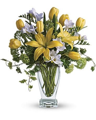 Teleflora's Spring Rhapsody - A rhapsody in yellow. Say "get well soon" or "have a happy day" with this sunny assorted bouquet. Everyone's favorite spring flowers are here - yellow lilies, yellow tulips, with accents of deliciously fragrant freesia flowers. Delivered by a florist in Teleflora's chic Couture Vase. Fragrant white freesia, fresh yellow tulips and asiatic lilies are mixed with beautiful green viburnum and graceful tendrils of ivy in a stylish, clear glass Couture Vase. Orientation: All-Around