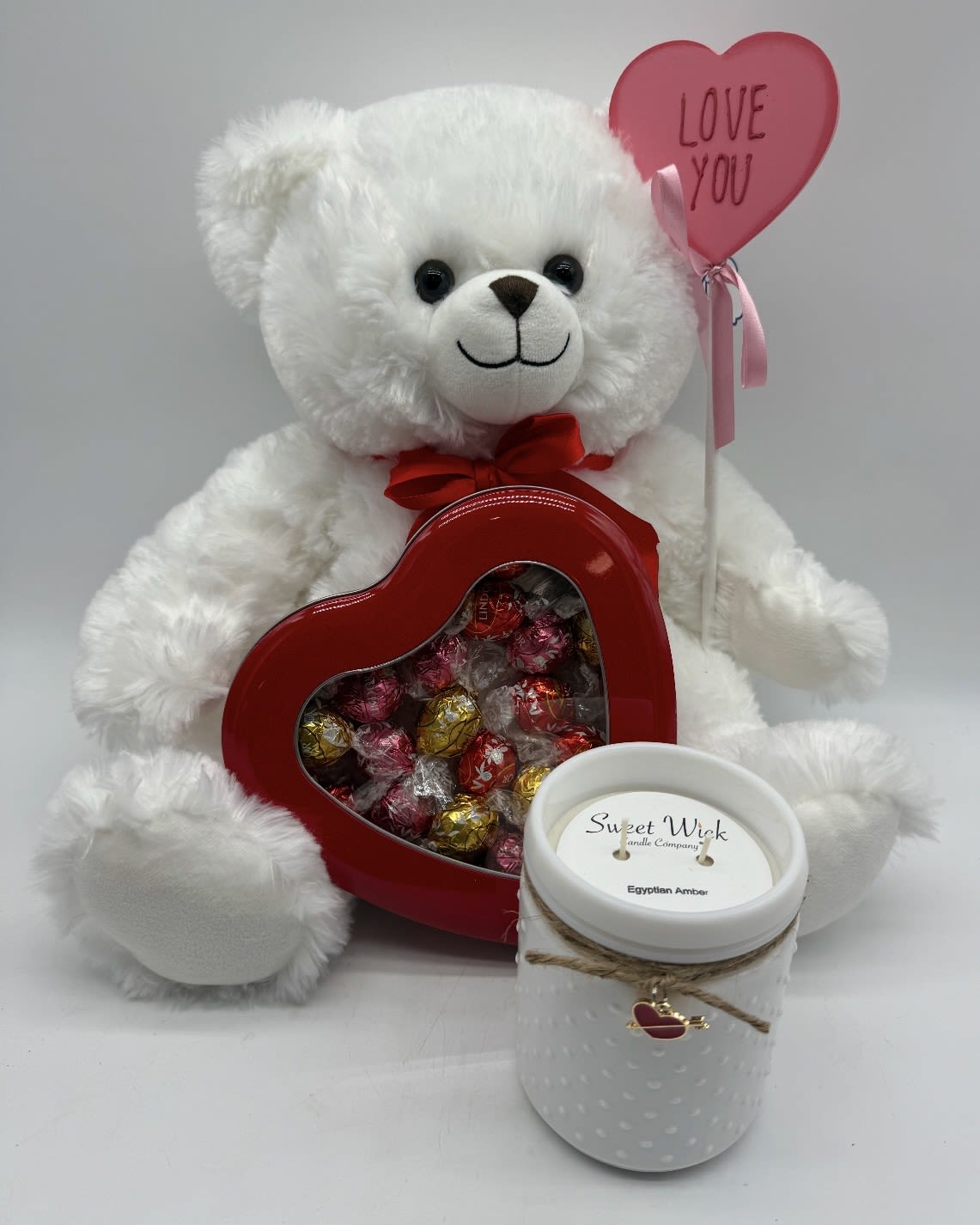BUNDLE OF 3 ~ BEAR, CHOCOLATES AND CANDLE $75 - Our large teddy bear (color may vary, white ~ brown).  Gourmet wrapped heart shaped milk chocolates in a tin and a fragrant Lush candle. 