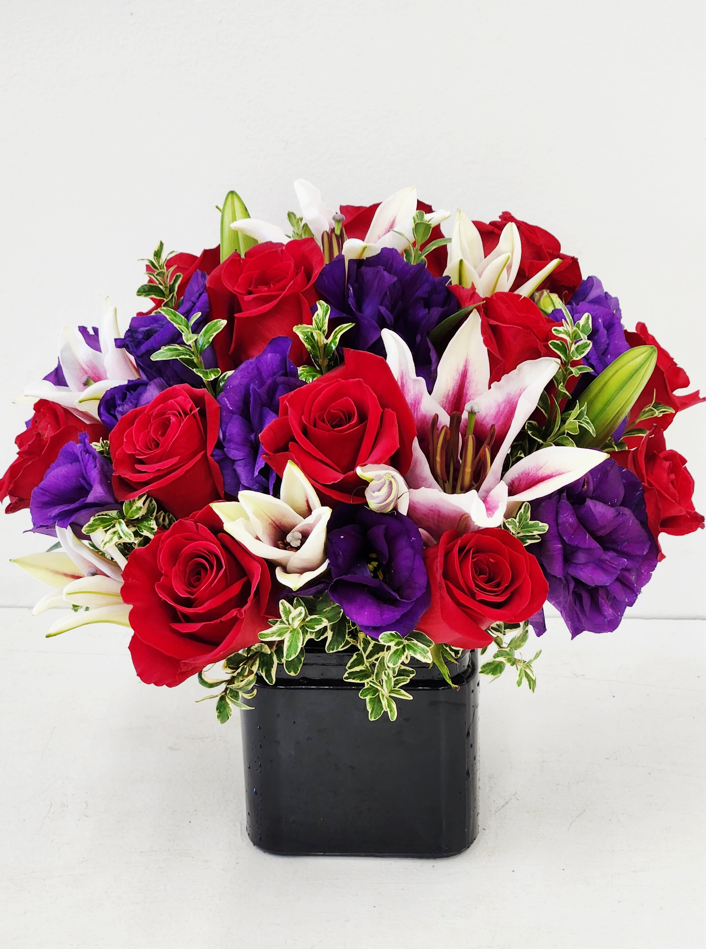 Jewels of Long Beach - Jewels of Long Beach is an elegant and luxurious arrangement designed to convey your most heartfelt emotions. This unique bouquet combines exquisite purple blooms in a sophisticated style, making it the perfect choice to express a profound and lasting love. Celebrate your special connection with a gift that stands apart in beauty and meaning. AS PICTURED: PREMIUM 24 PREMIUM RED ROSES. 12" WIDE BY 10" TALL