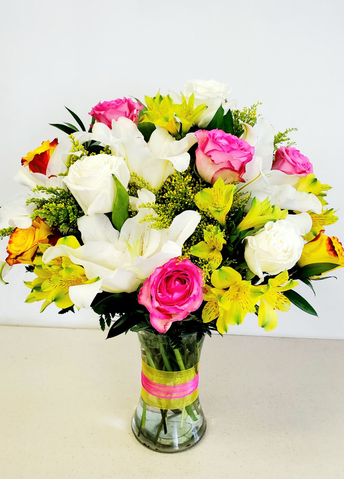 Sunshine at The Pike - Everyday flowers need not be boring. Sunshine at The Pike is unique and beautiful.  Send this bright bundle of sunshine to brighten their day.   White, yellow and pink roses, Oriental and Peruvian lilies, together creates a beautiful blend of cheerfulness.  Perfect for all occasions.   Maybe designed in any color on hand. Please indicate color preferences under instructions.