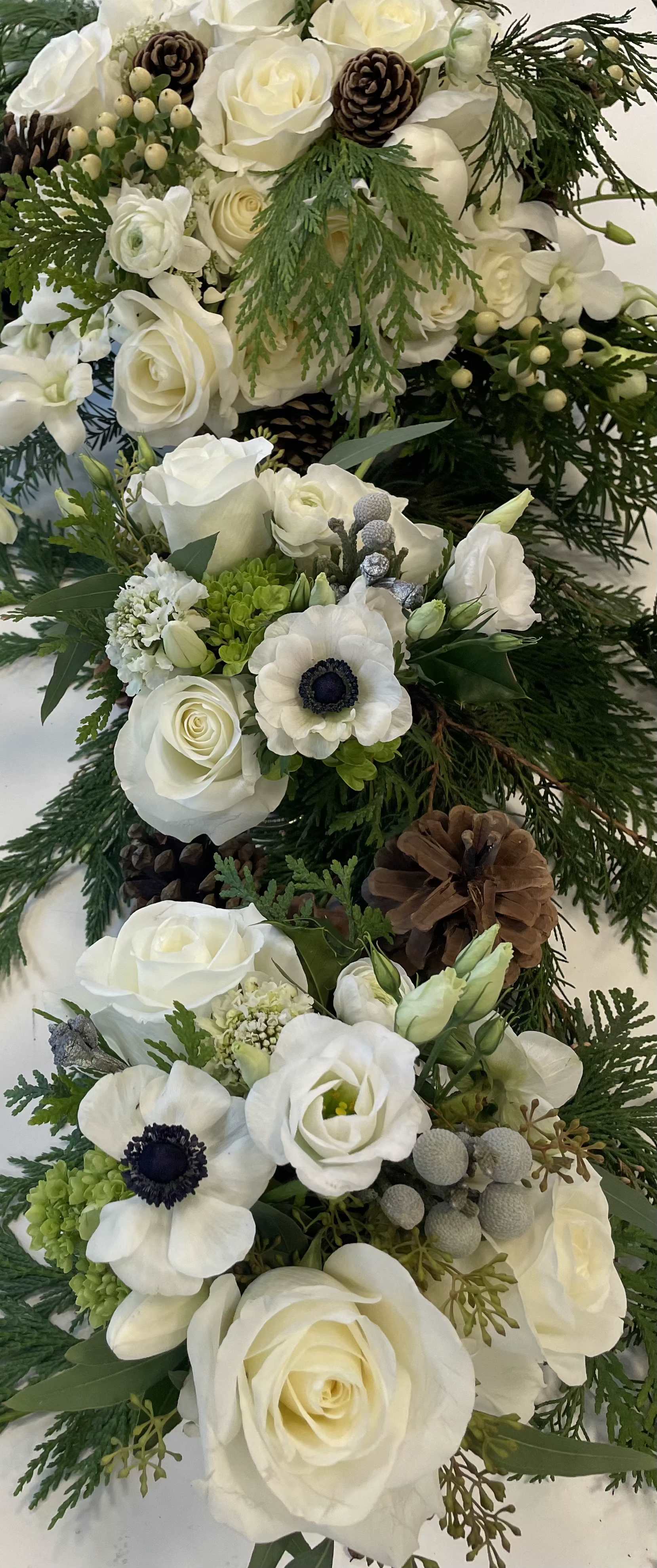 Winter White - Roses, anemones, hydrangea, brunia, and pine cones all white with a touch of green