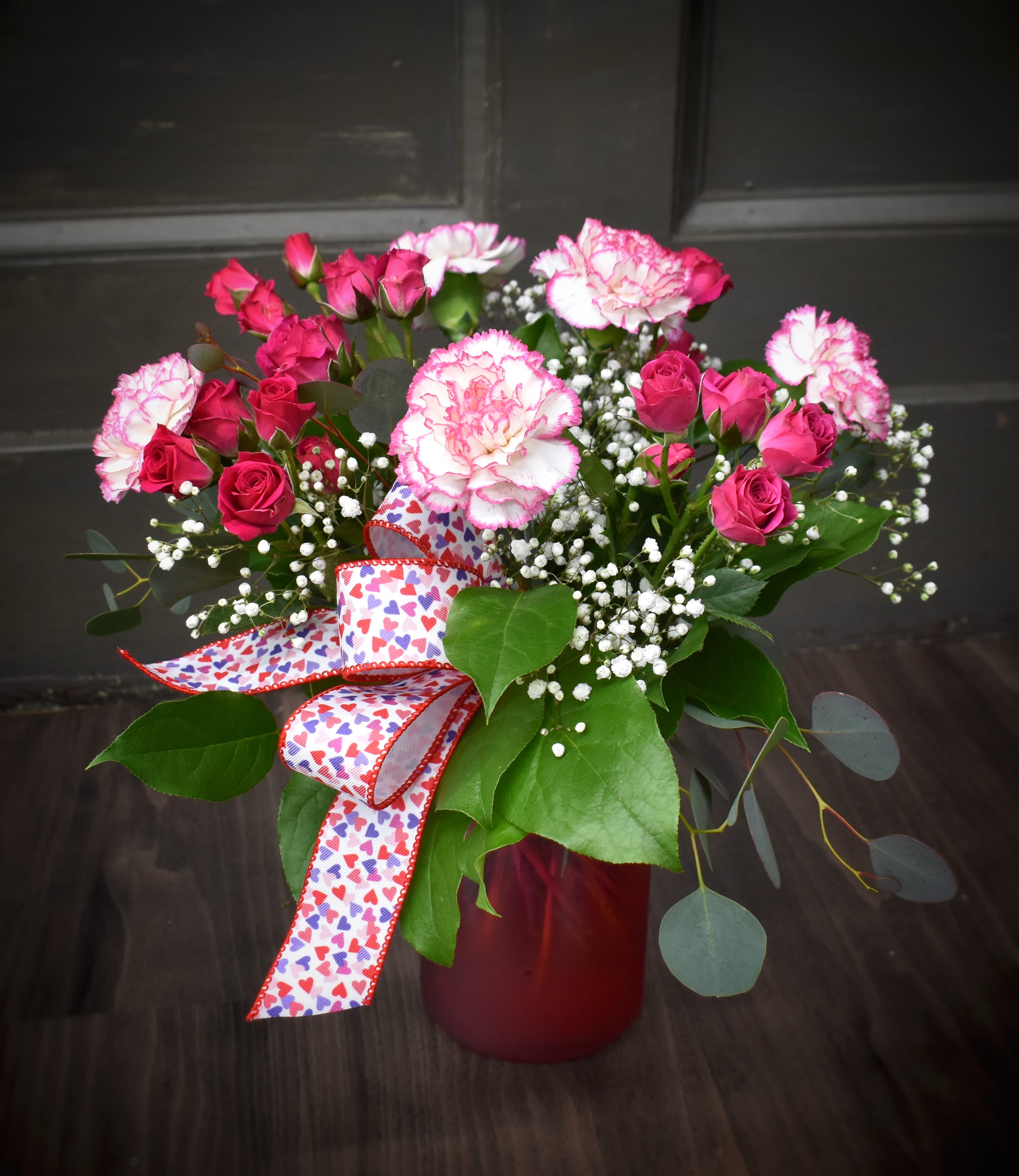 Sweet Petite - Available for Local St. Cloud, MN Delivery Only - This desktop sized bouquet is exactly as the name describes, Cutie Patootie and Sweet &amp; Petite! Spray roses, carnations, babies breath and foliages designed in a pretty red vase.