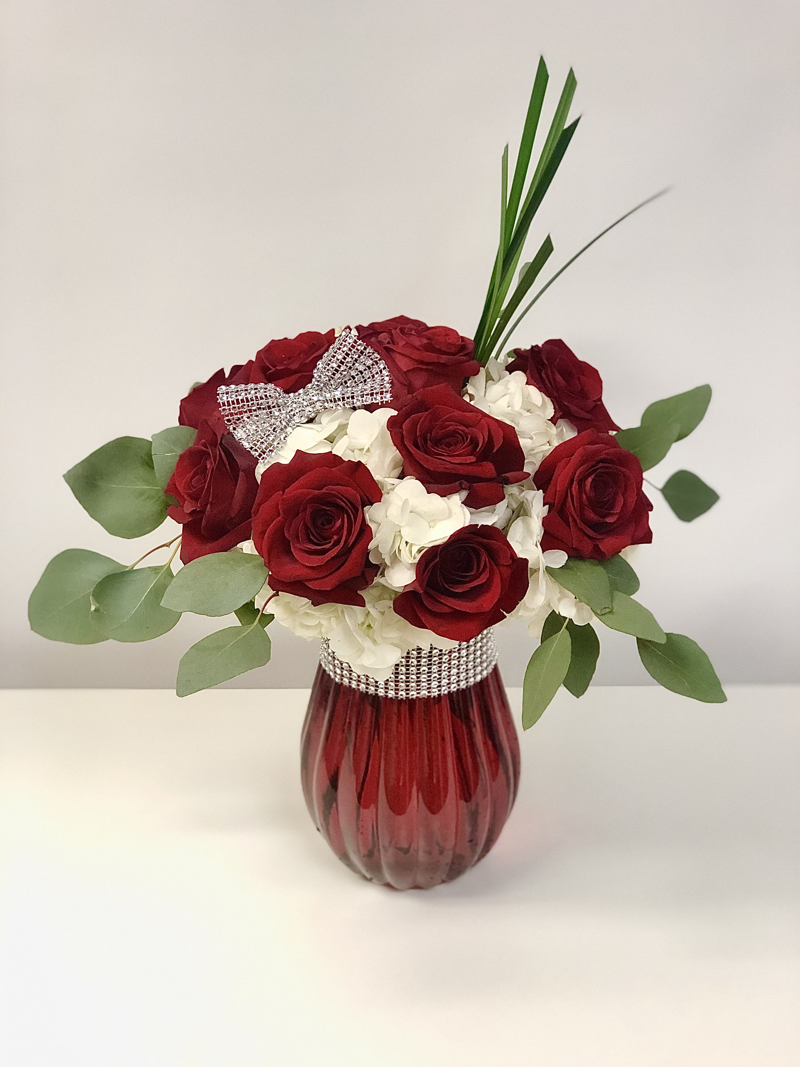 Sweet and sassy - Red roses, white hydrangea in a red vase with silver, gold, or rose gold (based on availability) accessories 