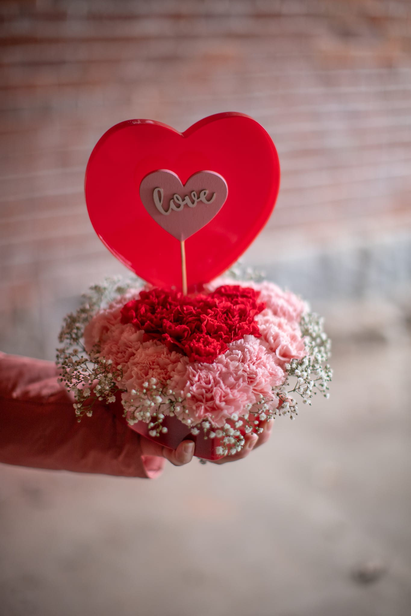 Pavé Heart - You might as what is a pavé floral arrangement? Pavé is a French word meaning paved. The pavers on cobblestoned streets are set together very tightly and compactly, hence the concept of this style of flower arrangement. Long lasting dianthus blooms are placed together very tightly in an acrylic heart shaped box container creating a perfect memento of love. Acrylic heart box is approximately 6.5 inches by 7 inches by 2 inches deep. The box comes with a lid prop and can be used after the fact as a storage box with lid open or closed. Pattern of carnations may vary from photo but will have the essence of Valentine's Day.