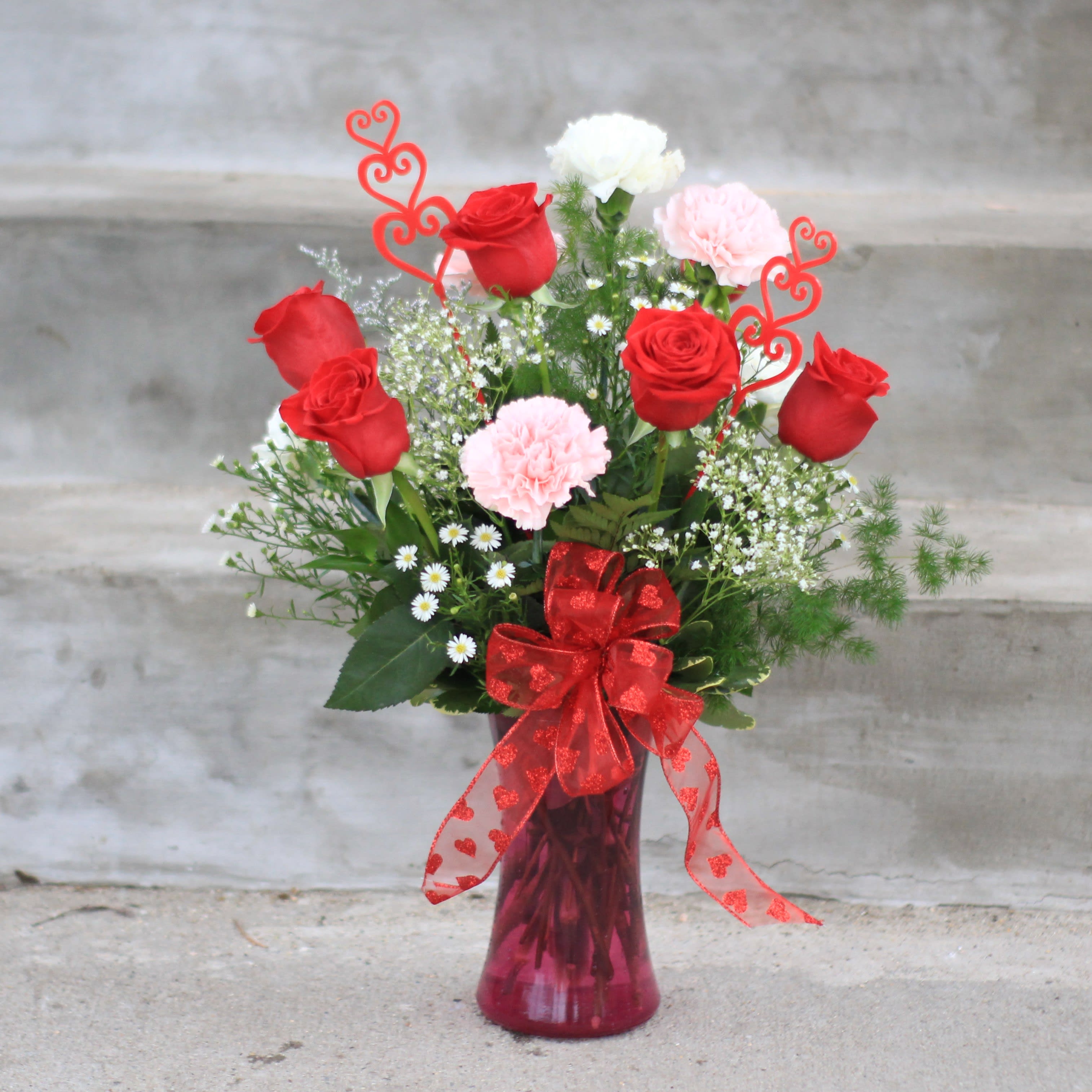 The 6 &amp; 6 Love Dozen - A Valentine's Day favorite is the traditional 6 roses and 6 carnations. Flowers are arranged in a clear glass vase or holiday color glass with seasonal greenery and filler flowers like lamonium, statice and baby's breath. Carnation colors will vary during the holiday. Carnation colors are white, pink, red, hot pink and purple. If you would like to customize your color choices please call to check availability. We are always happy to customize! 