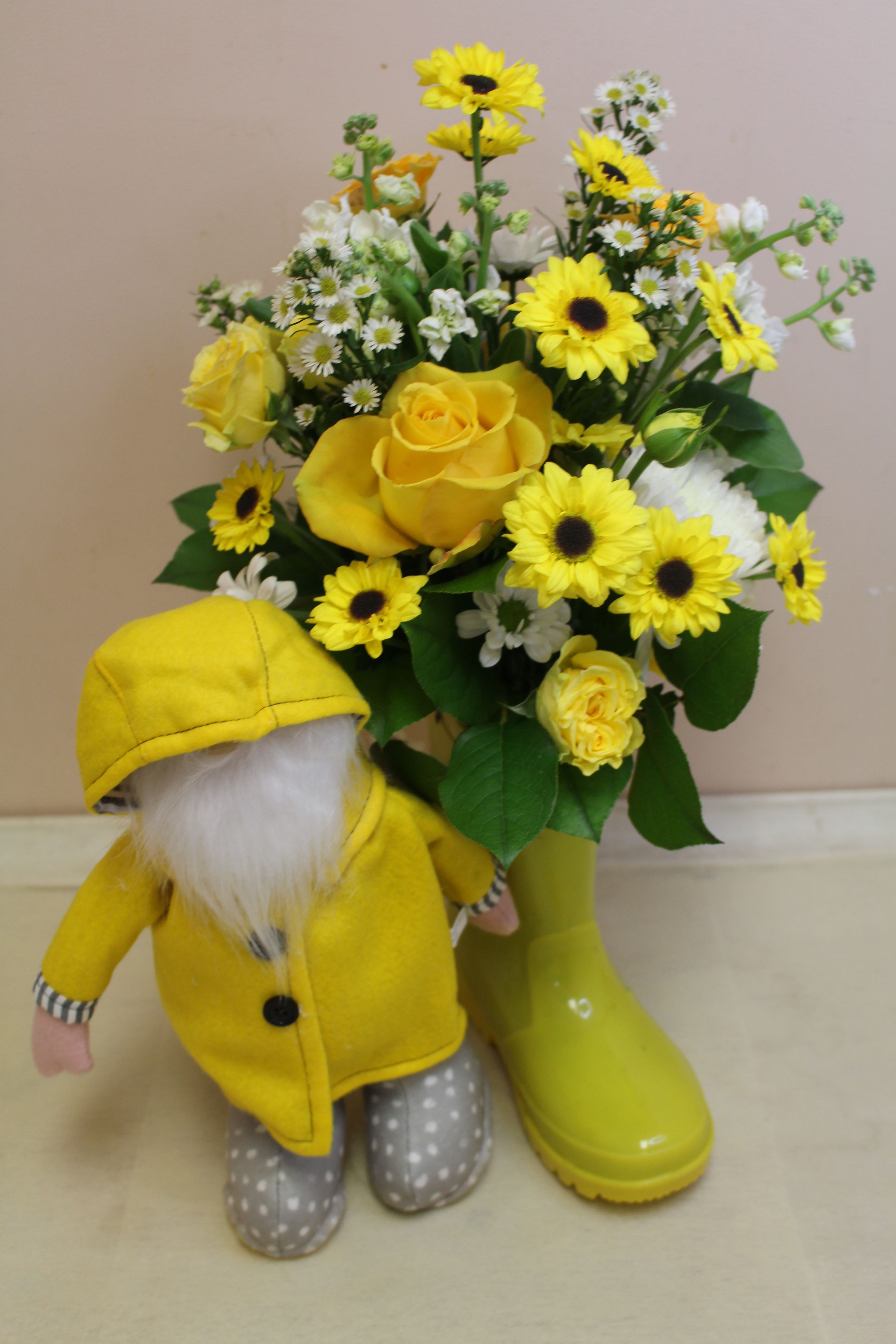 Rain showers bring May flowers - A cheerful spring arrangement with a cute gnome in a slicker, happily nestled inside a colorful rain boot!