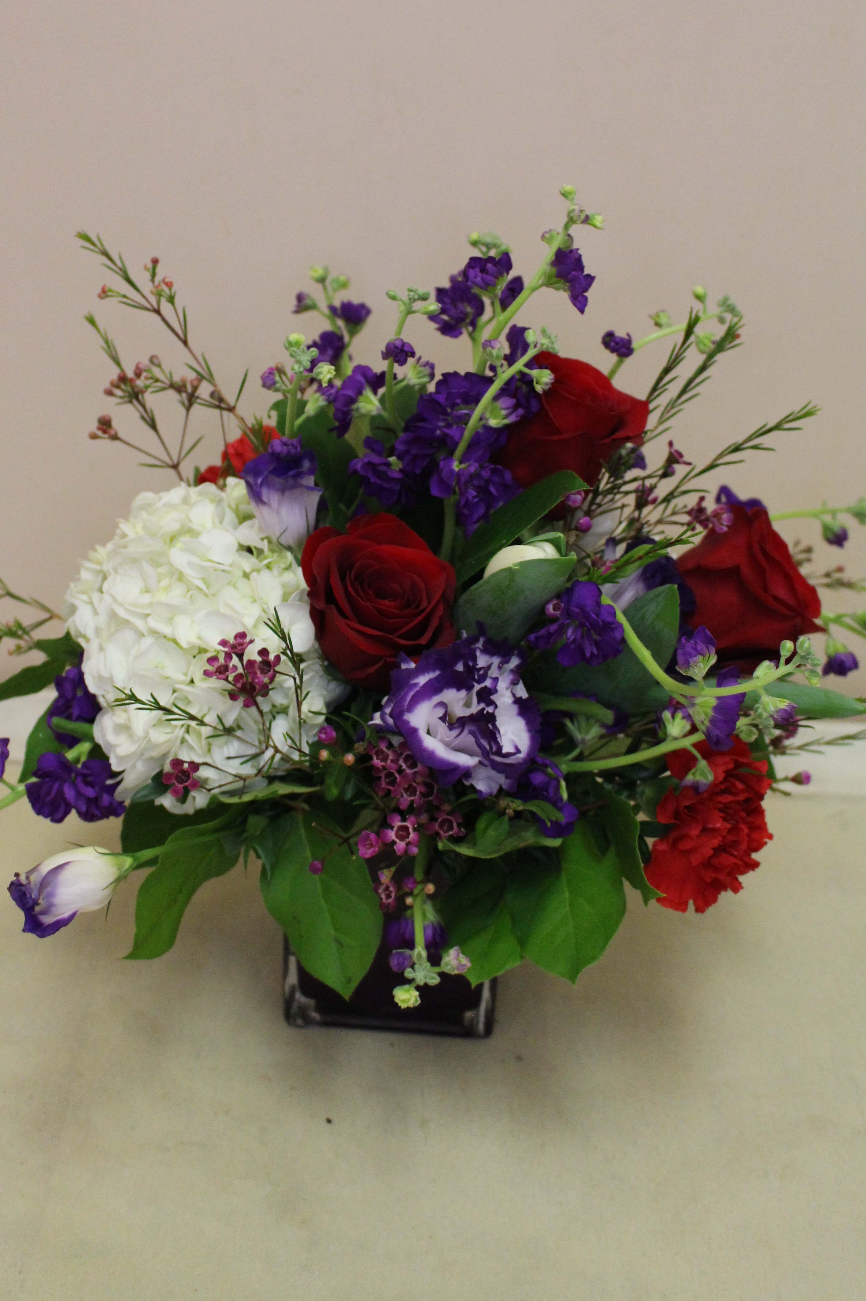 Passionate Purple - A unique, deep, purple cube filled with a vivid flower arrangement.  Including roses, hydrangea and  florigene carnations.  Perfect for the ones passionate about purple