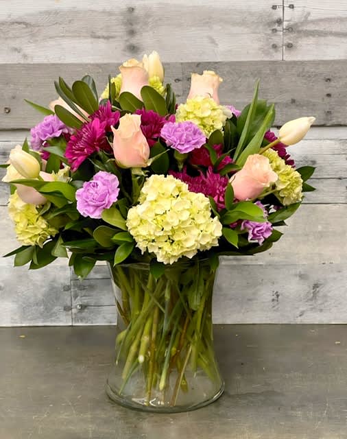 Springtime in Paris - This romantic gift is sure to make their fancies take flight. Roses, tulips, carnations and more - in the prettiest hues of pink, purple, white and green - create a beautiful all-around bouquet.