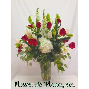 Tribute of Love - Red and White roses, white hydrangea, hybrid lilies, snapdragons and bells of Ireland with eucalyptus greens in a grand design. May substitute another color of hydrangea.