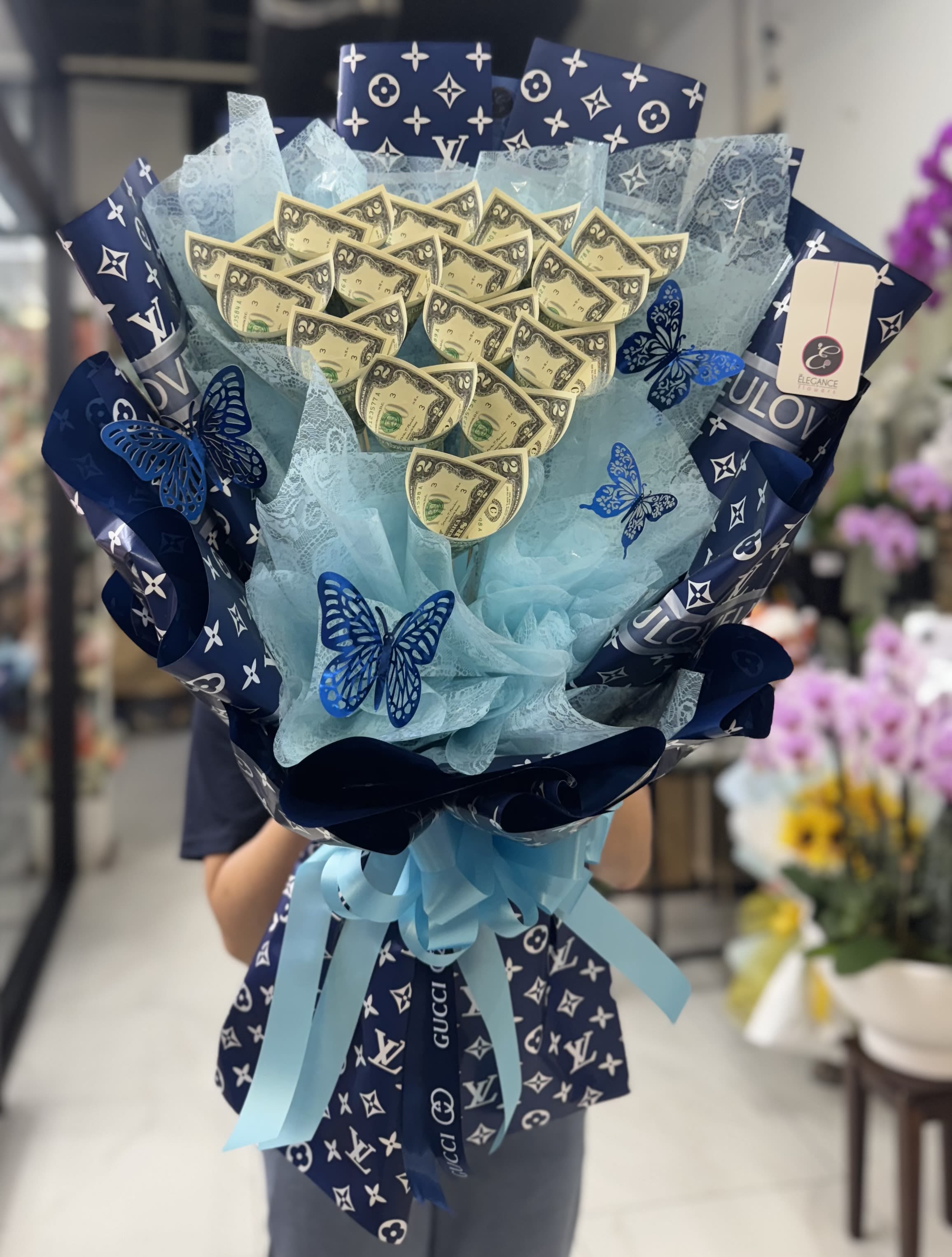 Money Bouquet #19  - Includes $2x 15 ($30), Please place your order 2–3 days in advance to ensure availability.  For questions, call us at 281-564-2600. Money bouquets are unique arrangements featuring dollar bills. They make a creative and luxurious gift for special occasions like birthdays, anniversary, or graduations, combining elegance with practicality.