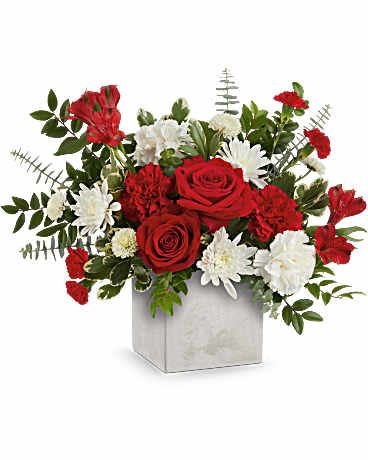 Loves Me Bouquet - A bold statement of affection, the Loves Me Bouquet blends classic red and white blooms in a sleek, concrete-inspired cube for a look that's both romantic and contemporary. Bouquet features red roses, red alstroemeria, red and white carnations, miniature red carnations, white button spray chrysanthemums, and white cushion spray chrysanthemums, accented with spiral eucalyptus, huckleberry, and variegated pittosporum. Presented in the Modern Paradise Cube, a chic concrete-inspired vase. Approximately 17 3/4" W x 14 1/2" H