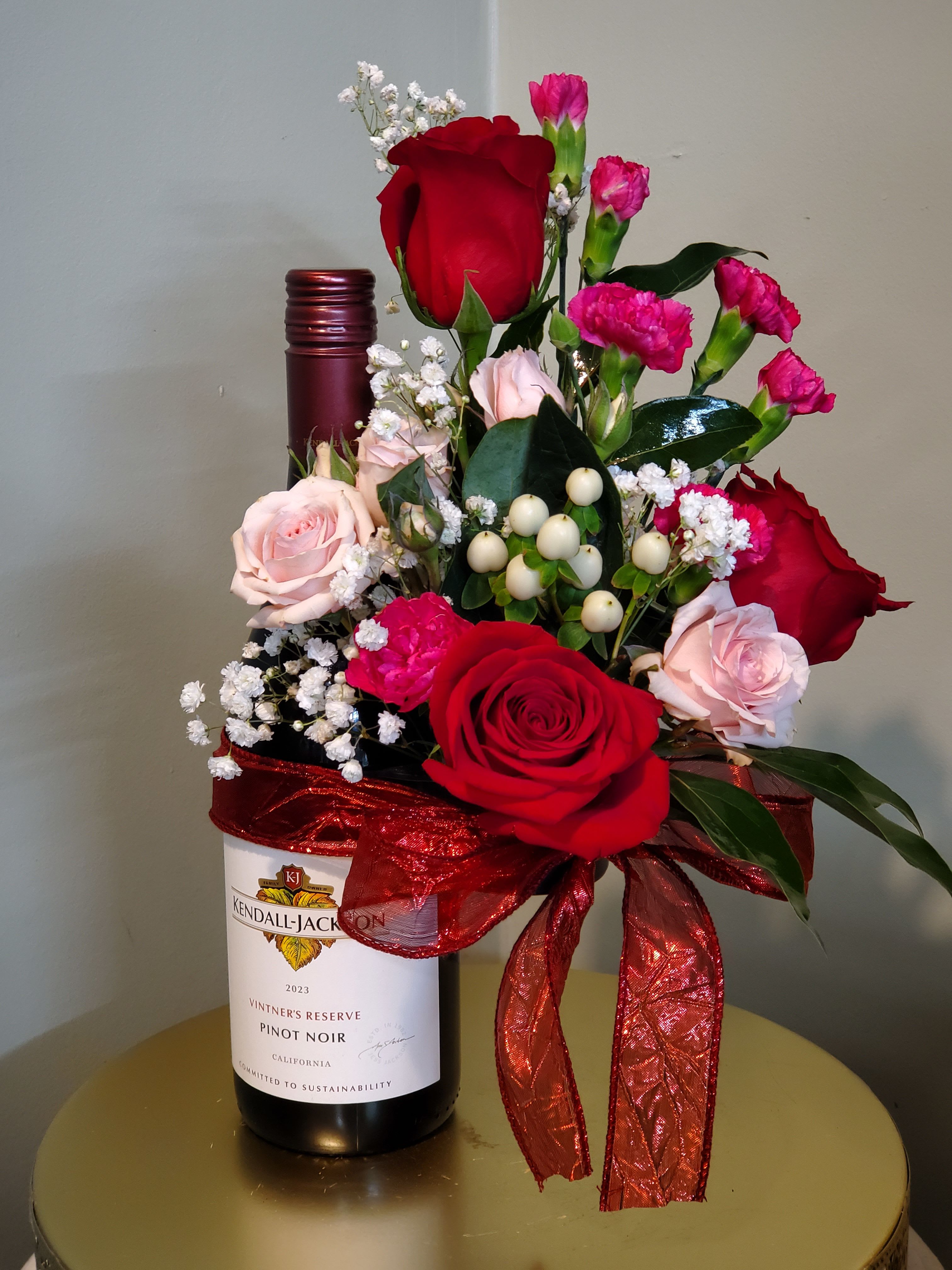 WINE NOT - WINE not included.  Bottle holder with flowers..... Starting price 45.00. You can choose other flowers for extra. The hardware slides right on the wine bottle, and use the ribbon to cover hardware.