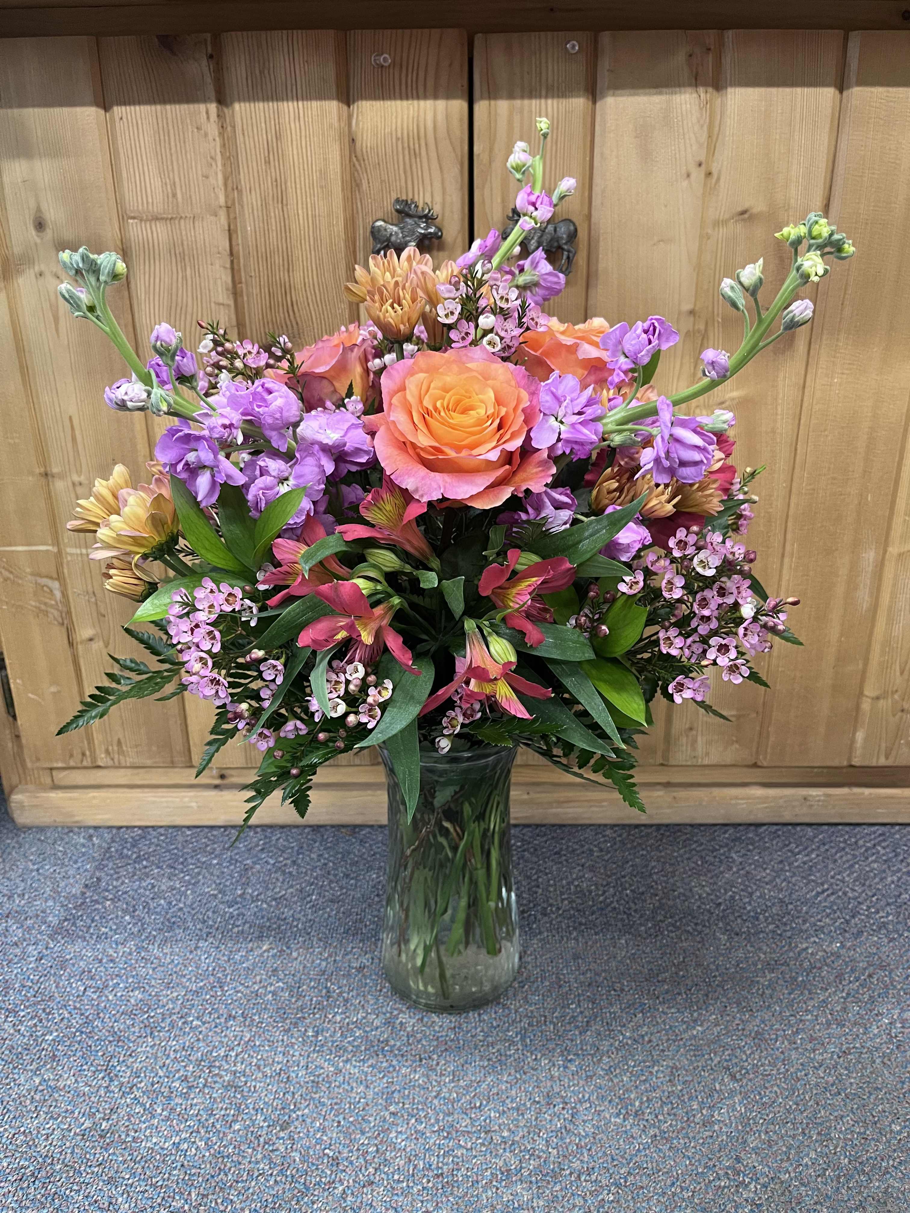 Tropical Oasis  - Need a warm sunny get away?  We may not be able to help you with that, but with the Tropical Oasis arrangement, you can bring a that warm sunny vacation feel right into your home, a loved one's home, or office space!  This stunning arrangement features warm colors using alstroemeria, roses, daisies, stock, and wax flower. 