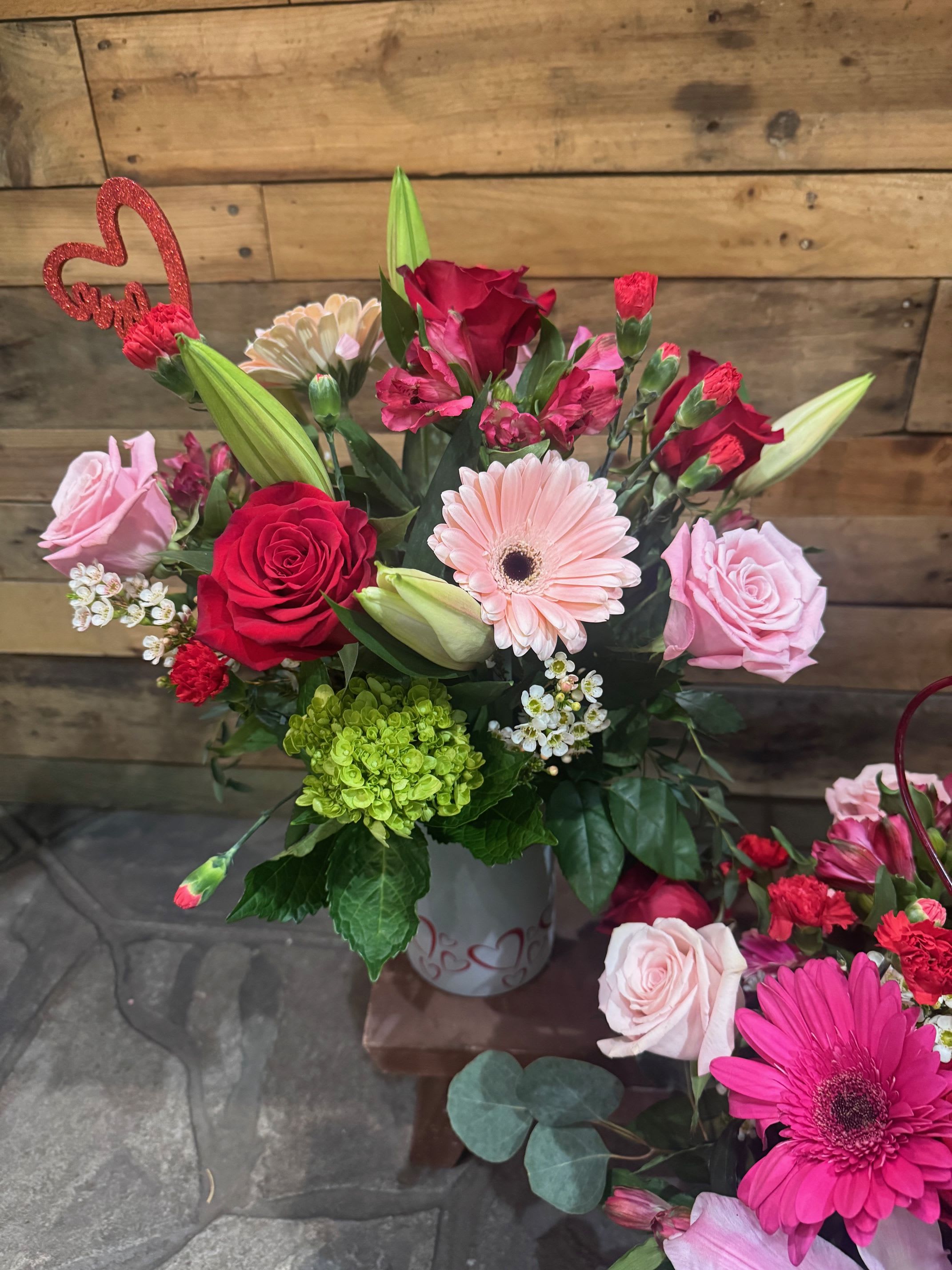 The Sweetheart - This arrangement contains different shades of pink roses and also red roses. It can also include some gerbera daises and even lilies. It can also include some fillers like eucalyptus and wax flower.