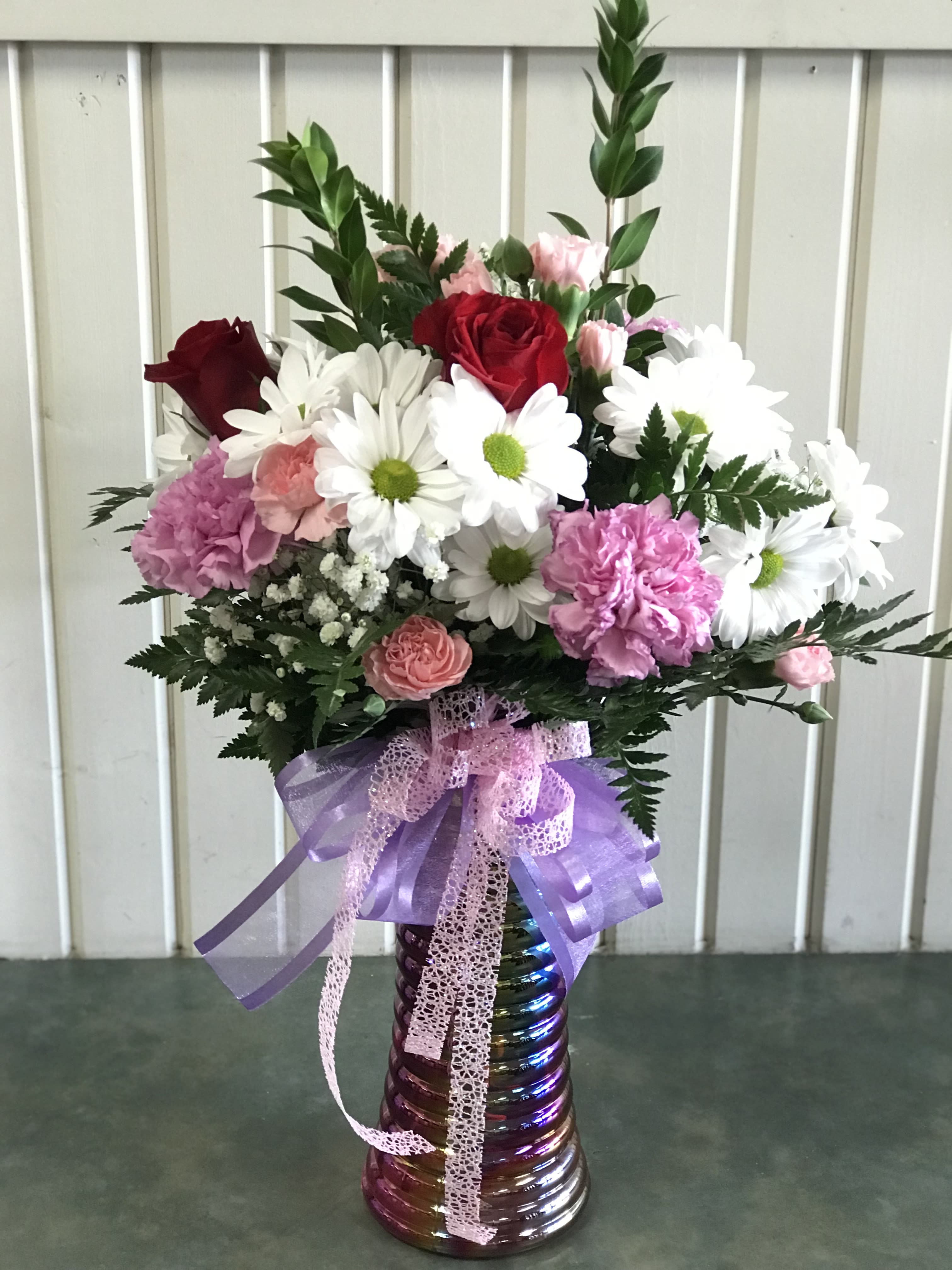 Valentines DELUXE Designers Choice  -  assortment of red, pink and lavender/purple flowers including four roses with a valentine ribbon