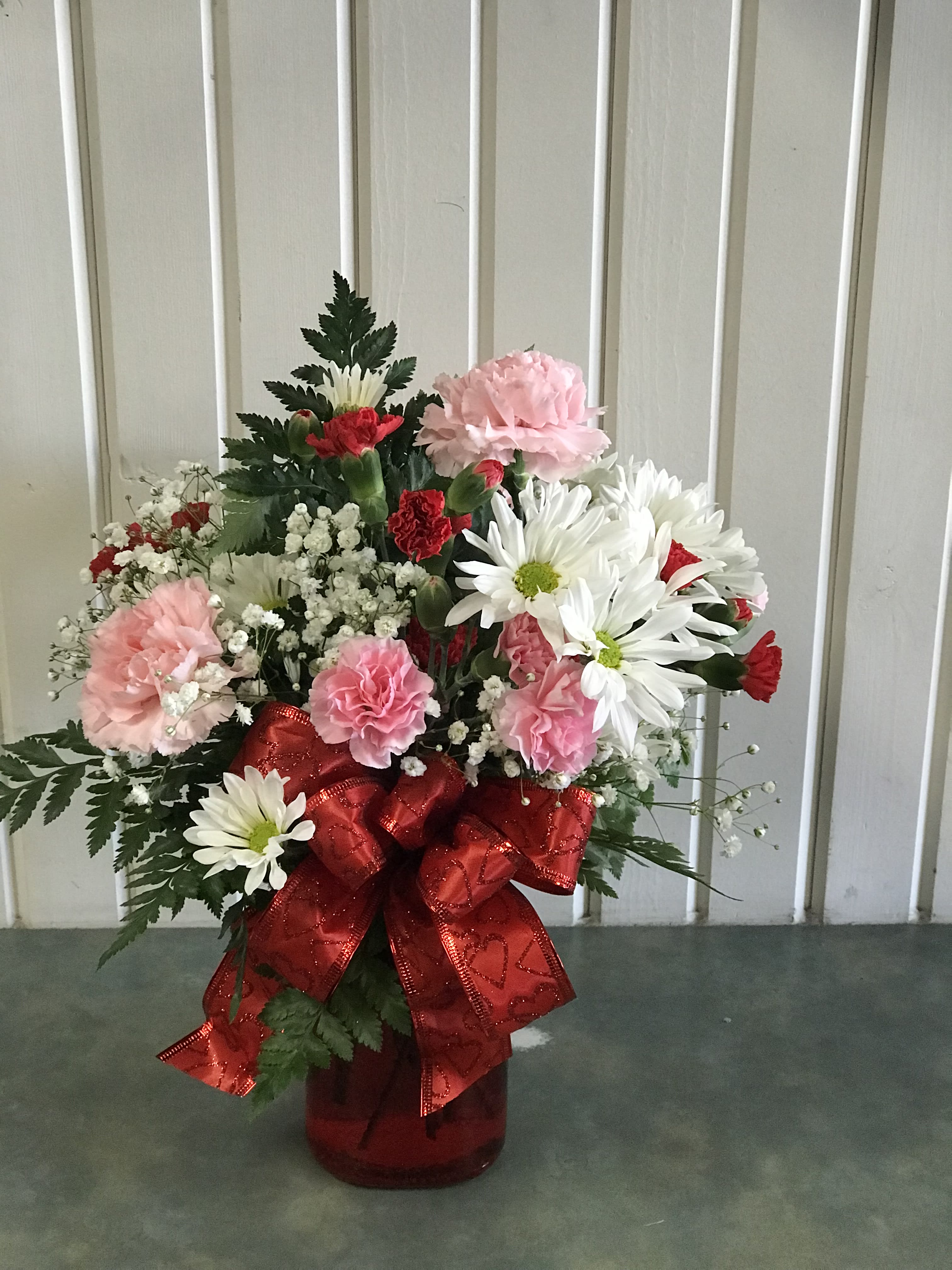 Valentine STANDARD DESIGNERS CHOICE  -  assortment of red, white &amp; pink daises, carnations &amp; pretty filler with a valentines ribbon in an adorable valentine container.