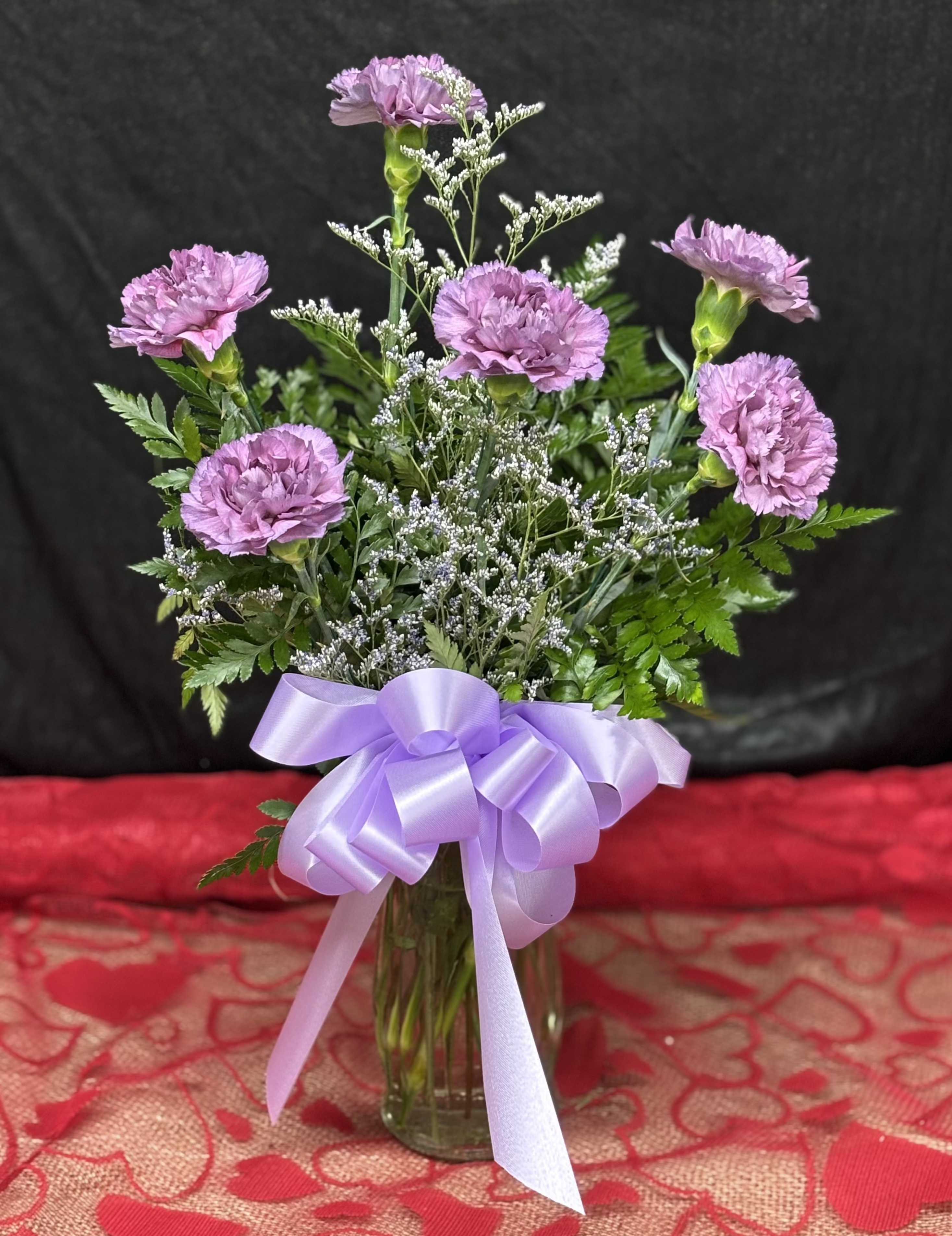 Cloud Kisses - A tall and whimsical arrangement of lavender carnations nestled among delicate sprigs of cassia, as light and dreamy as a kiss from the clouds. This design evokes a serene, airy charm, perfect for lifting spirits and brightening spaces. 