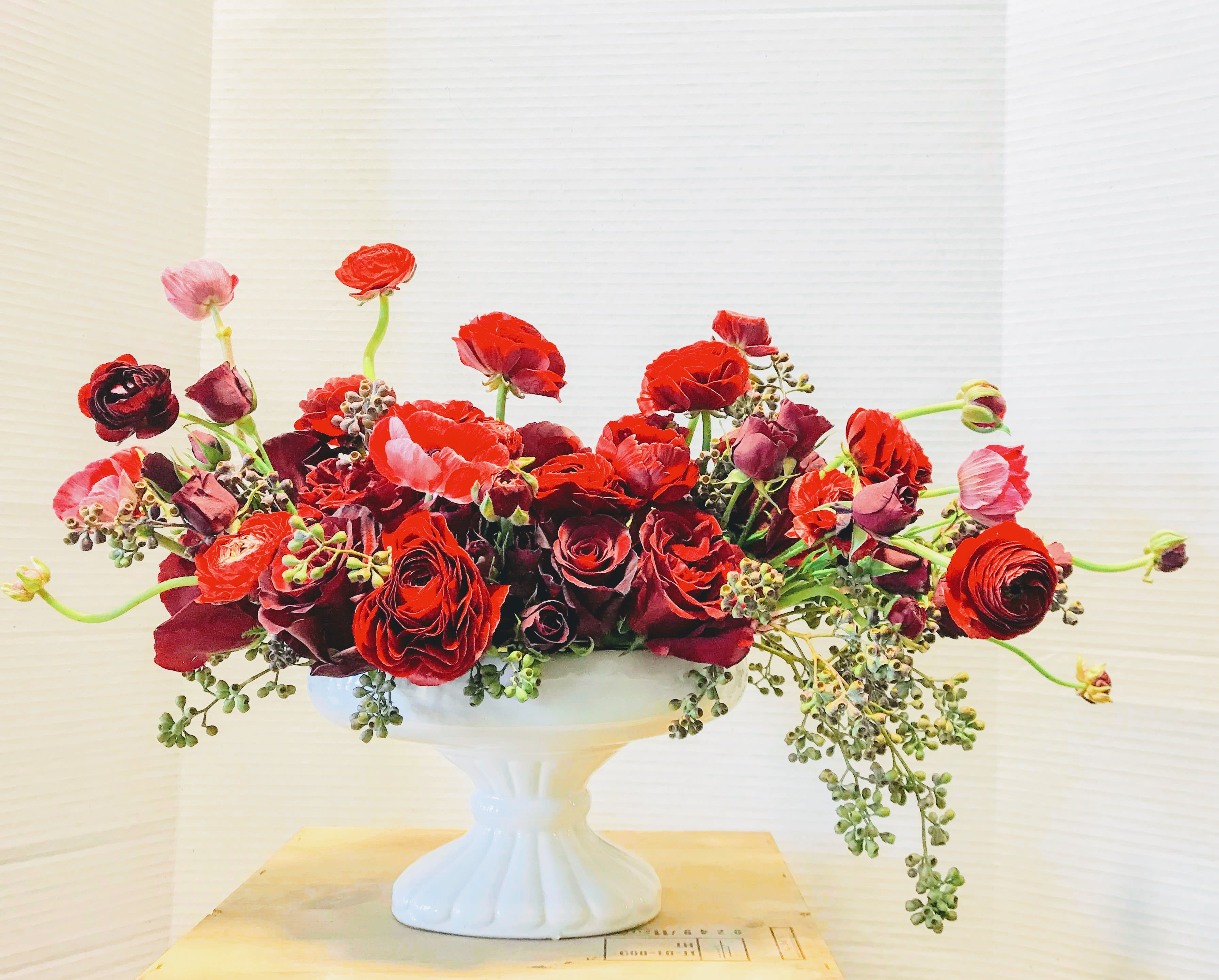Love up on a pedestal - Oblong pedestal bowl filled and overflowing with red roses and ranunculas
