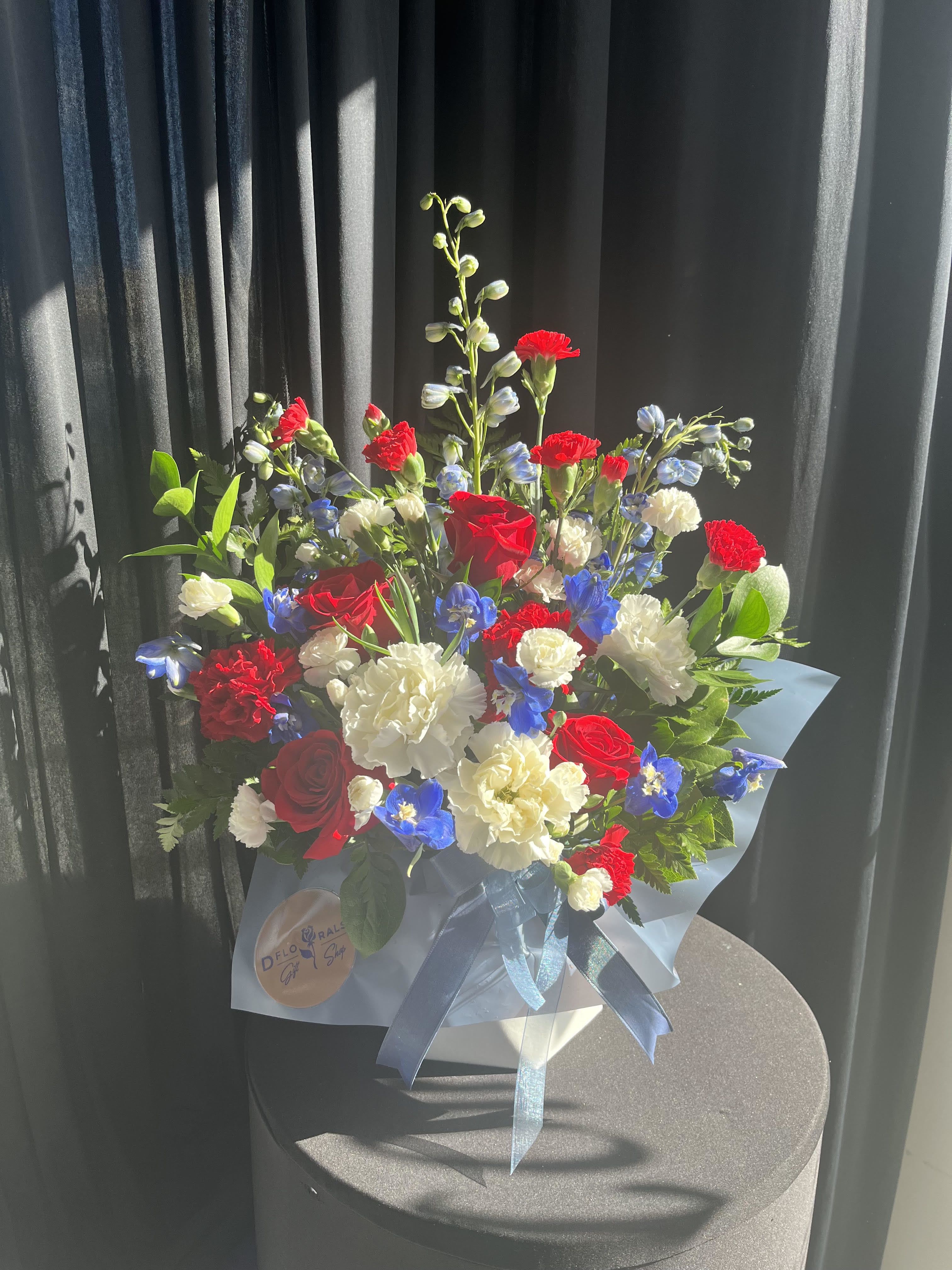 Red &amp; blue, white box   - We are dedicated to delivering your emotional sentiments with the utmost care, ensuring that each arrangement is fresh, beautiful, and arrives on time. Due to the natural variability of flowers, as well as seasonal and regional availability, substitutions may occasionally be necessary. Rest assured, any substitutions will be of equal or greater value, and we will make every effort to preserve the overall design, including the shape, size, style, and color combinations of the arrangement. In the case of single-variety arrangements, the specific variety will take precedence over color to maintain the intended look and feel. Thank you in advance for understanding that flowers are a natural product and may vary slightly in appearance.  Substitution Policy In some instances, our photo may represent an overall theme or look and include a one-of-a-kind vase which cannot be exactly replicated.  Although the actual bouquet may not precisely match the photo, its temperament will. Occasionally, substitutions of flowers and/or containers happen due to weather, seasonality and market conditions which may affect availability. If this is the case with the gift you’ve selected, we will ensure that the style, theme and color scheme of your arrangement is preserved and will only substitute items of equal value or higher value.  If any design elements are of major importance to your order, please include them in the florist instructions at checkout or contact us to ensure availability.