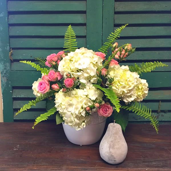 Blush and Grace - Celebrate Life’s Sweetest Moments with Elegance Send your heartfelt congratulations to proud parents, grandparents, or even siblings with our Blush and Grace arrangement. This stunning bouquet, featuring white hydrangeas, delicate pink roses, and lush fern foliage, is thoughtfully arranged in a sleek white ceramic container, making it a timeless and versatile gift.  Whether you’re celebrating the arrival of a new baby girl, sending a thoughtful "just because" gift, or brightening someone’s day, this arrangement is designed to bring joy and beauty to any space. Are you in search of a bouquet that is gender-neutral? Let us know in the "notes" section of your order, and we’ll adjust the arrangement to feature soft whites, greens, and neutral tones. 
