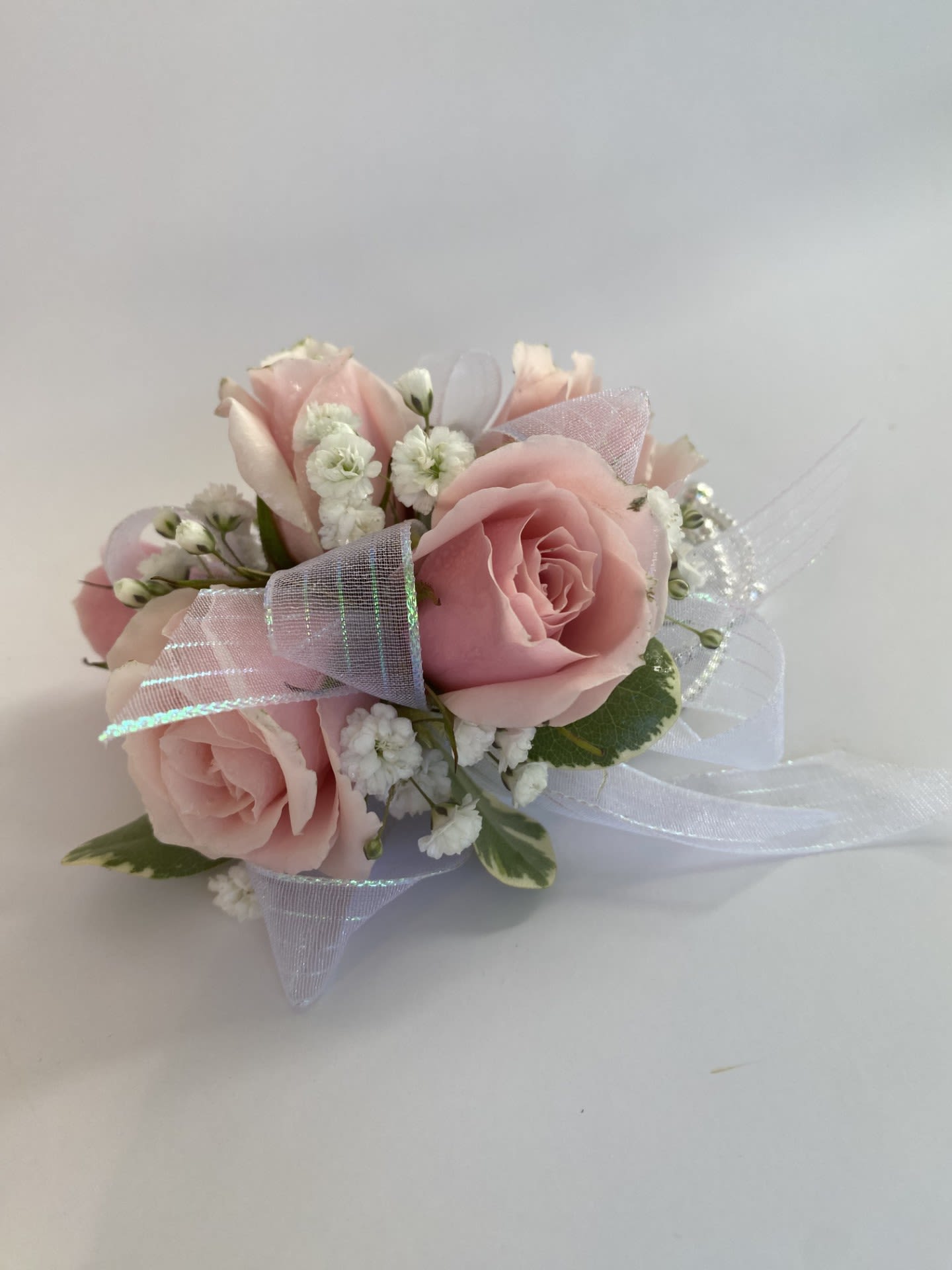 Corsage / Bracelet - Pink Spray Roses  - Elevate your formal attire with our Spray Rose Bracelet Corsage, a stunning statement piece handcrafted to make your special night truly unforgettable. Designed with the freshest spray roses and tailored to complement your unique style, this corsage is the perfect accessory for proms, homecoming dances, weddings, or any cherished celebration. Whether your vision is elegant, feminine, dramatic, or bold, our exquisite craftsmanship ensures a flawless design that reflects your aesthetic. -Key Features: **Fresh light Pink Spray Roses: Petite and elegant, spray roses add a delicate yet sophisticated charm to the corsage. **Customizable Design: Include your dress color, preferred ribbon shade, and any floral requests to create a personalized piece. **Secure Bracelet Base: Comfortable, adjustable band ensures a perfect fit for all-night wear. **Optional Floral Upgrades: Add your favorite blooms or seasonal flowers for a bespoke design (quote provided upon request). Order today and let us design a corsage that adds a touch of elegance and individuality to your unforgettable night! 